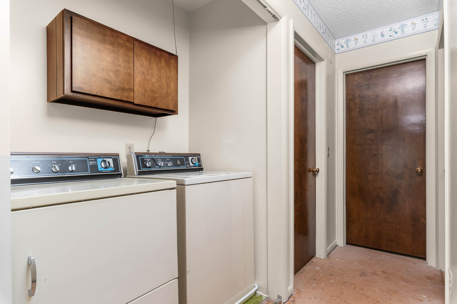 Dedicated laundry area featuring a wall-mounted wood-finish cabinet