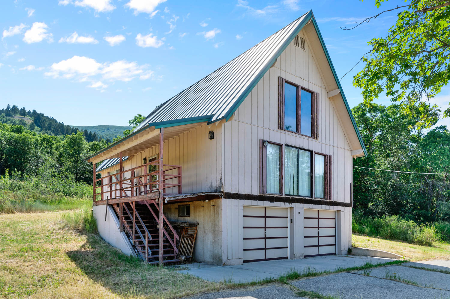 Two-story exterior featuring a prominent metal roof and board-and-batten siding