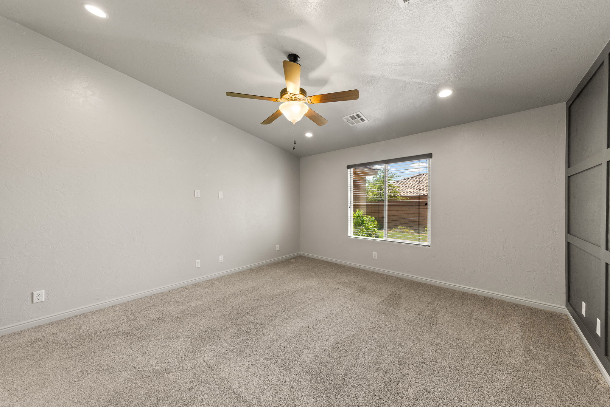 Spacious room featuring neutral carpet flooring, a ceiling fan with integrated lighting, and recessed lighting