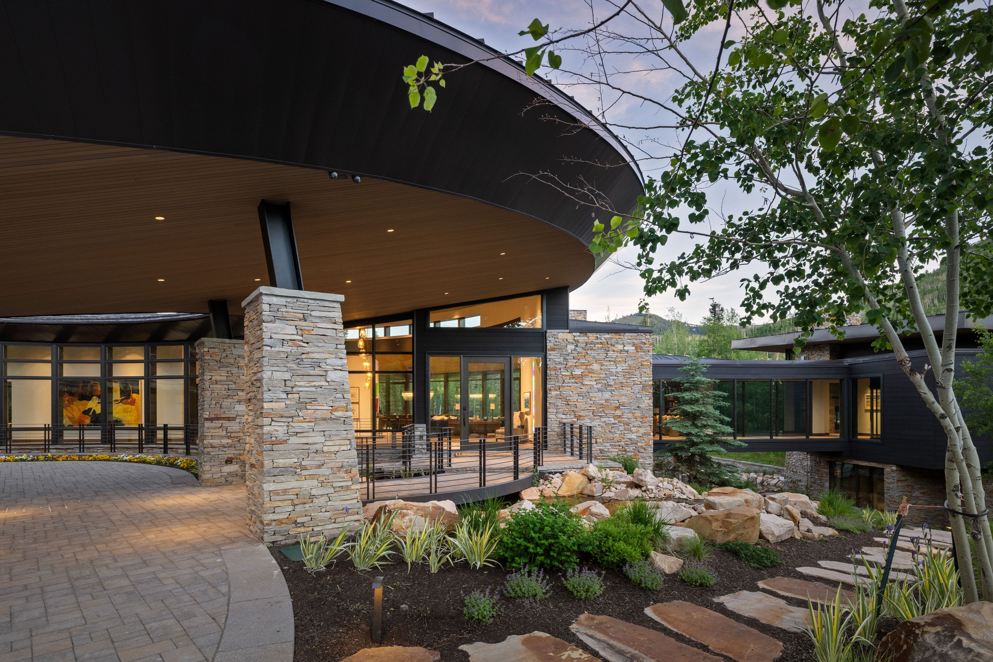 Modern architectural design featuring a circular porte-cochère with recessed lighting and a wood-finish ceiling