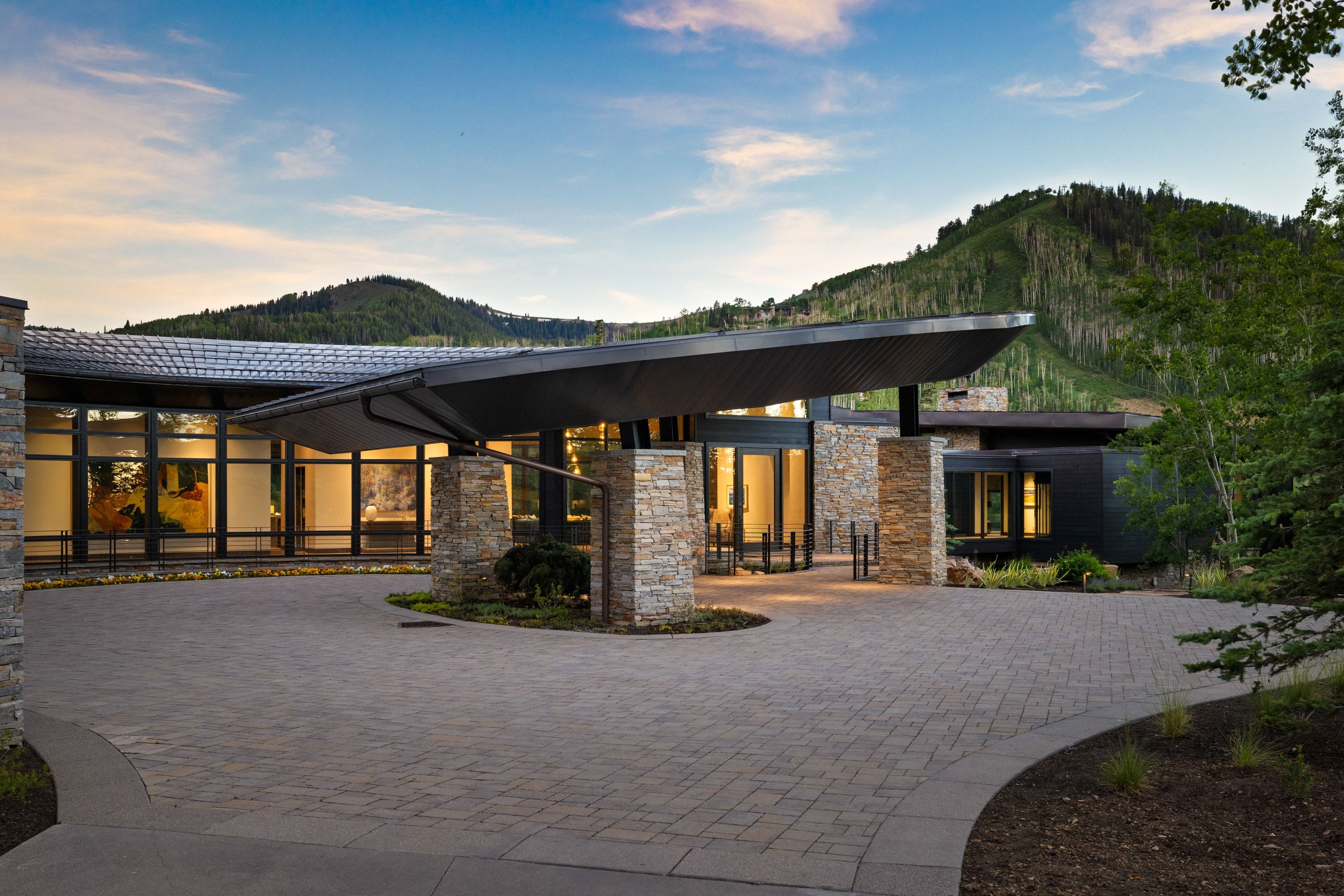 Expansive paver driveway leading to a contemporary residence