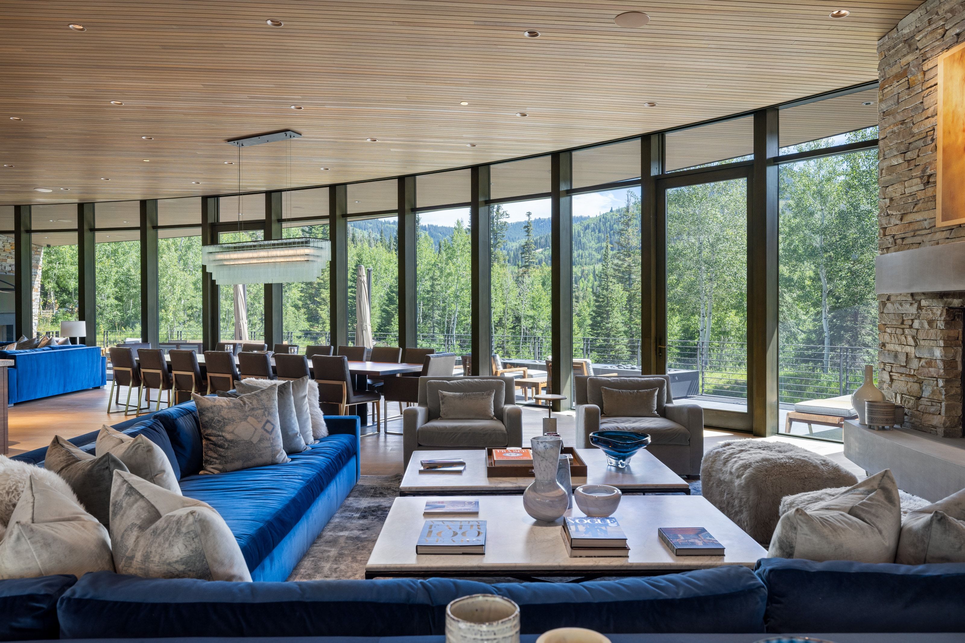 Curved wall of floor-to-ceiling windows frames the natural landscape