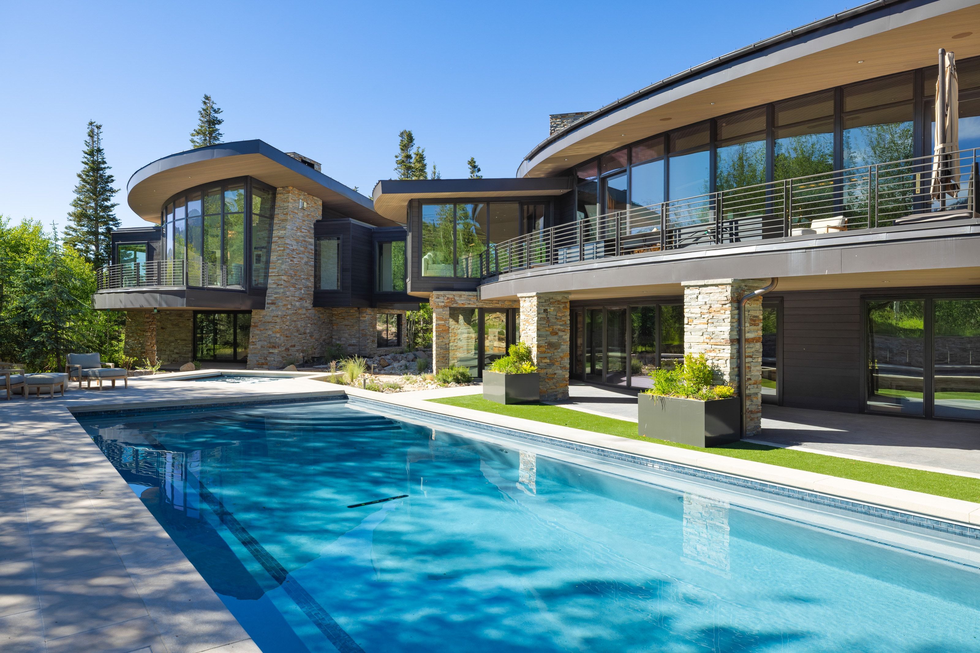 Expansive swimming pool with integrated spa and stone surround