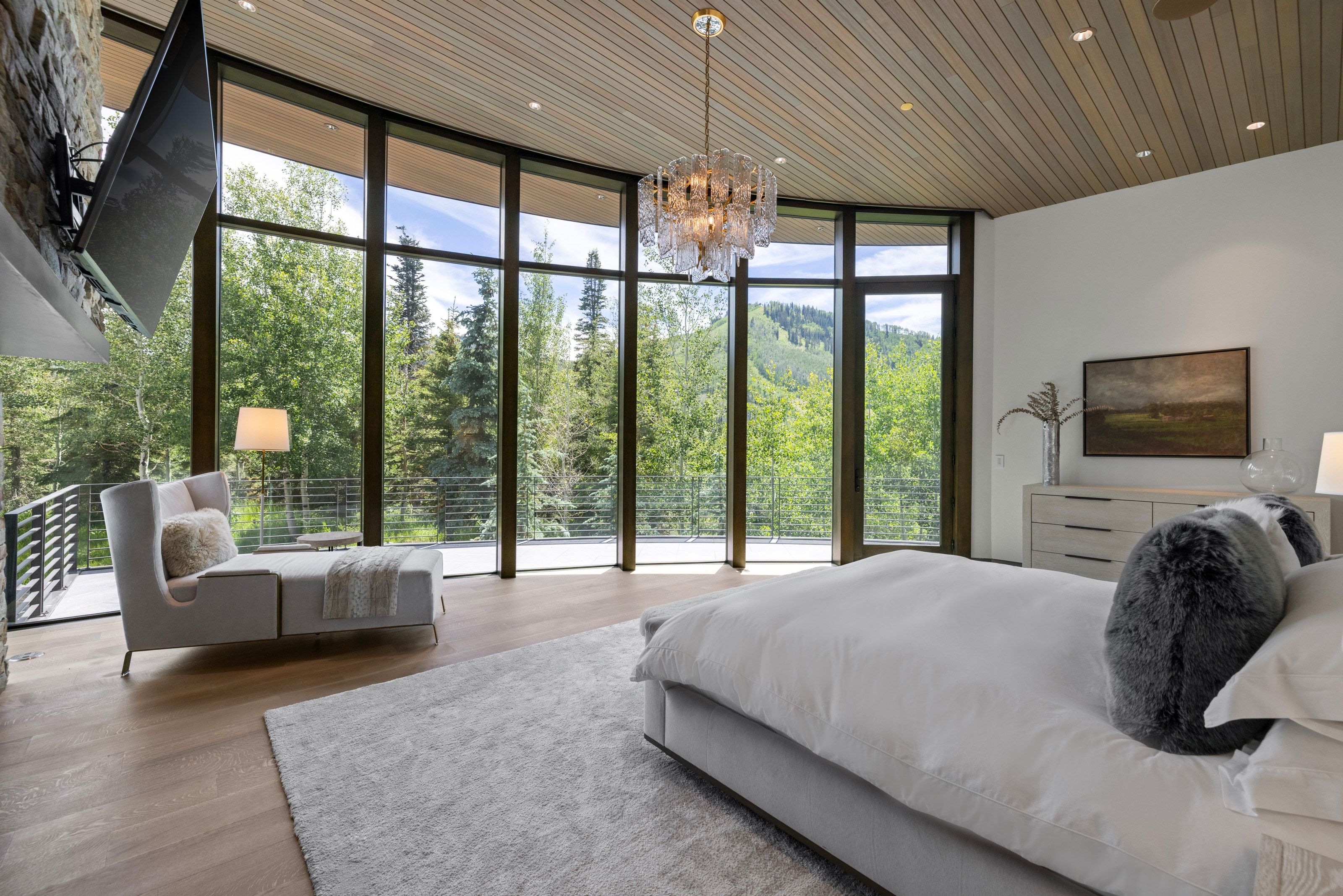 Floor-to-ceiling windows with expansive mountain scenery, wood-finish flooring, a wood-slat ceiling, and a modern chandelier