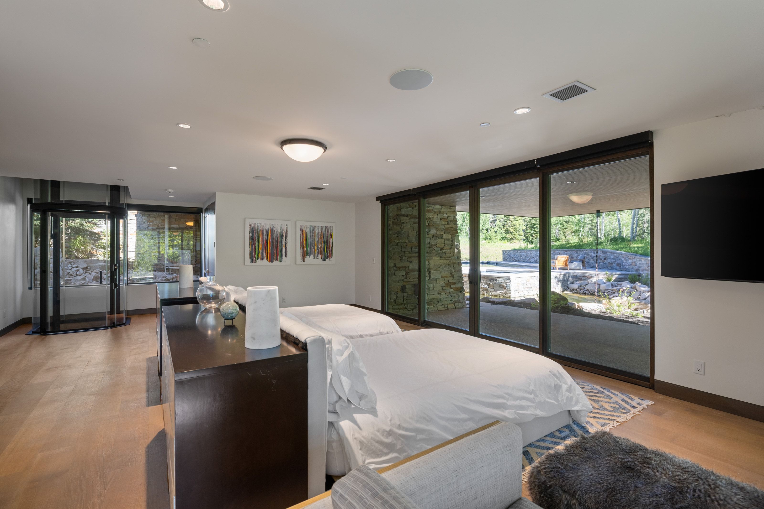 Expansive room featuring wood-finish flooring, recessed lighting, and a large wall-mounted display