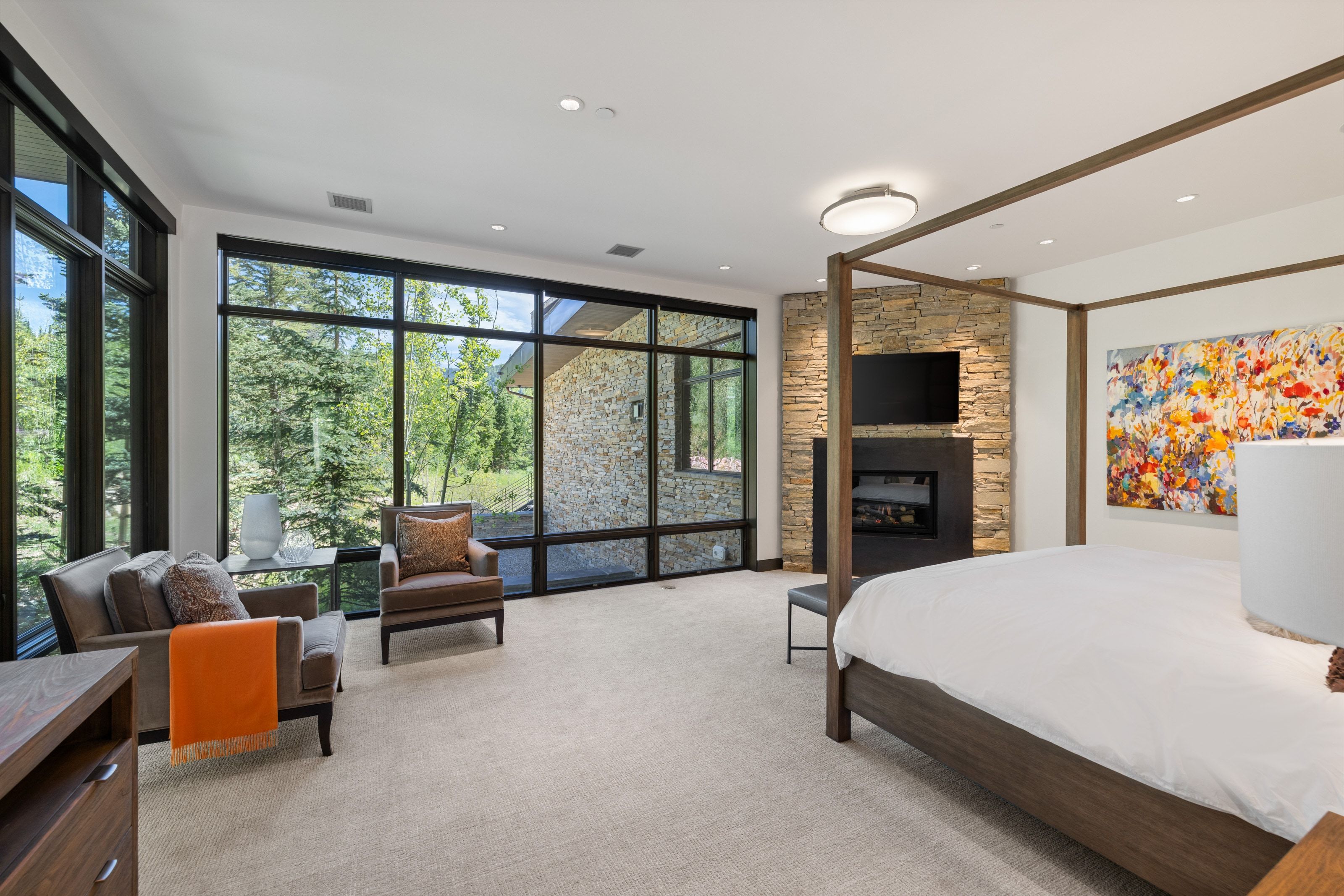 Expansive windows showcasing exterior stone cladding and surrounding trees