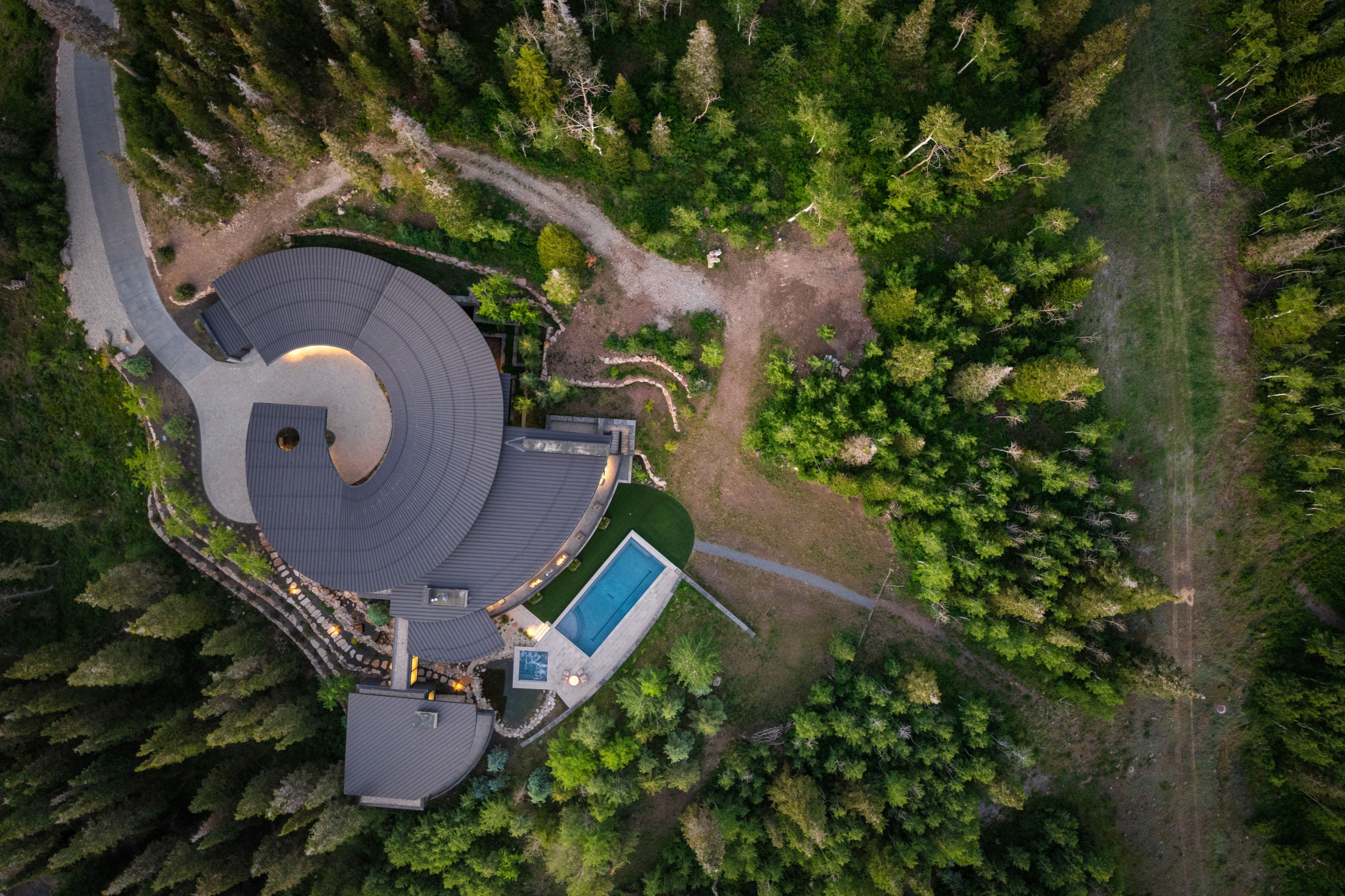 Curved architectural design with a dark panel roof and integrated exterior lighting