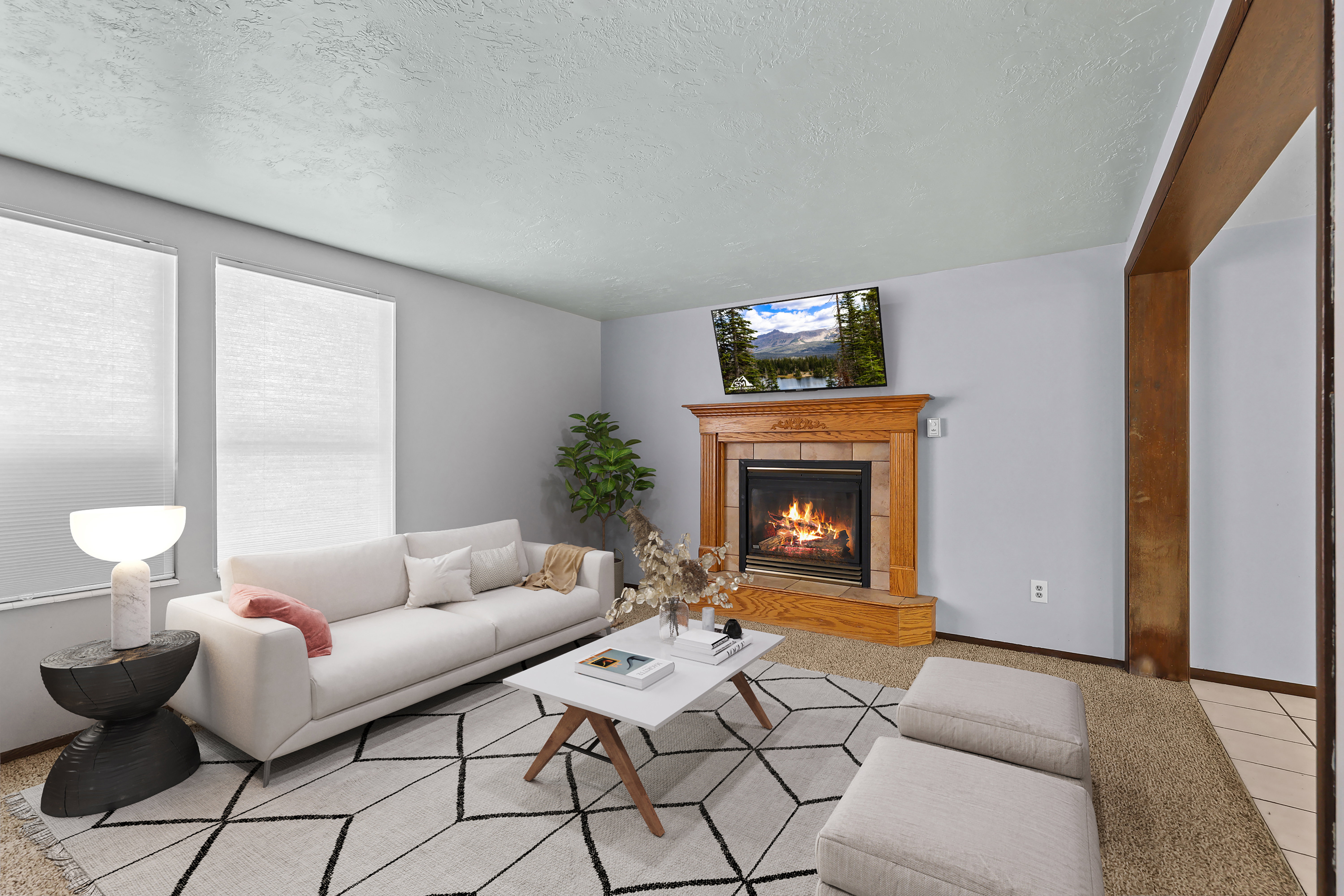 Living area featuring a prominent corner fireplace with a wood mantel and tile surround