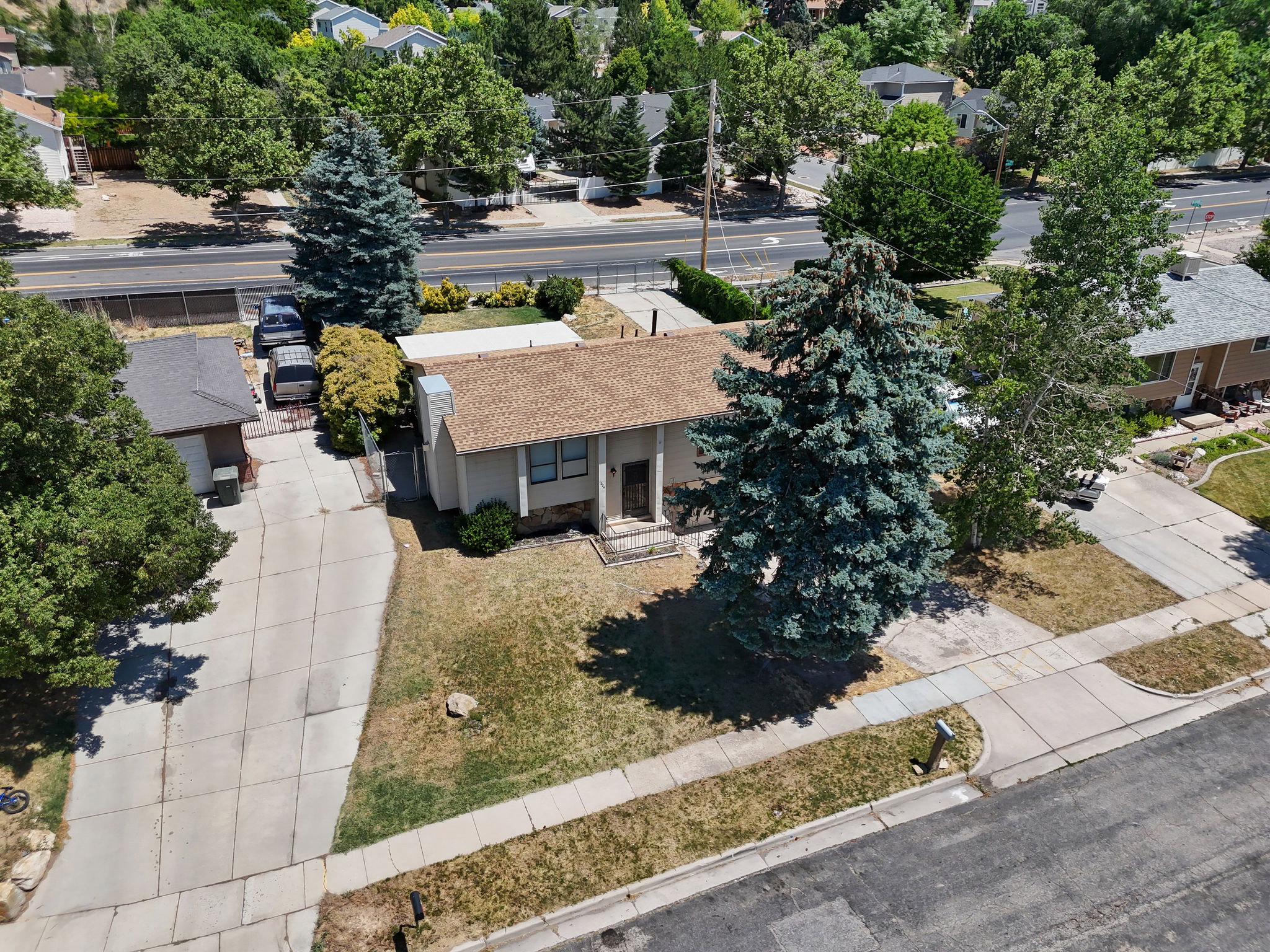 Single-story residence featuring a brown shingle roof, concrete driveway, and a detached single-car garage