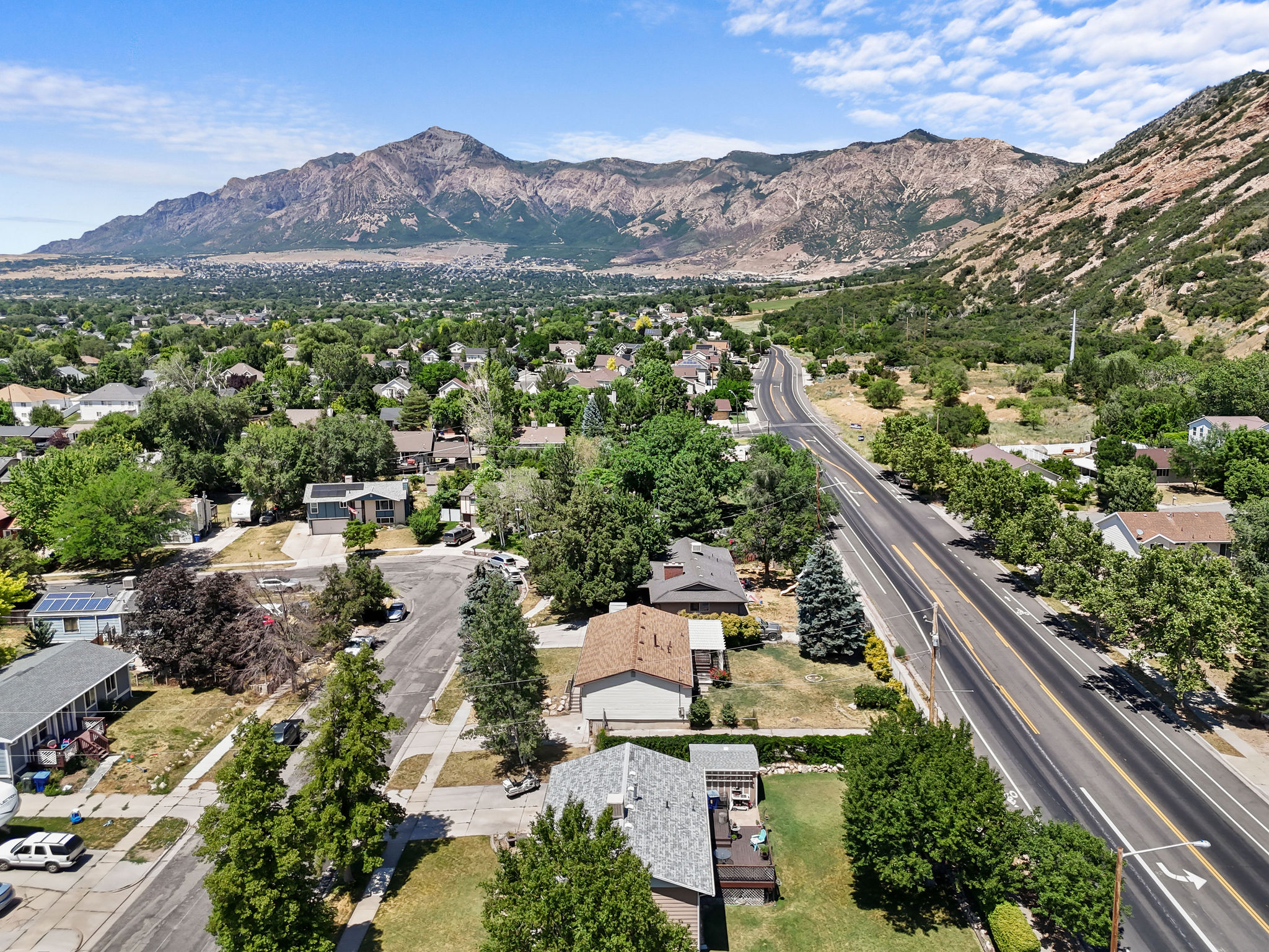 Expansive aerial capturing a suburban landscape with a prominent mountain range backdrop