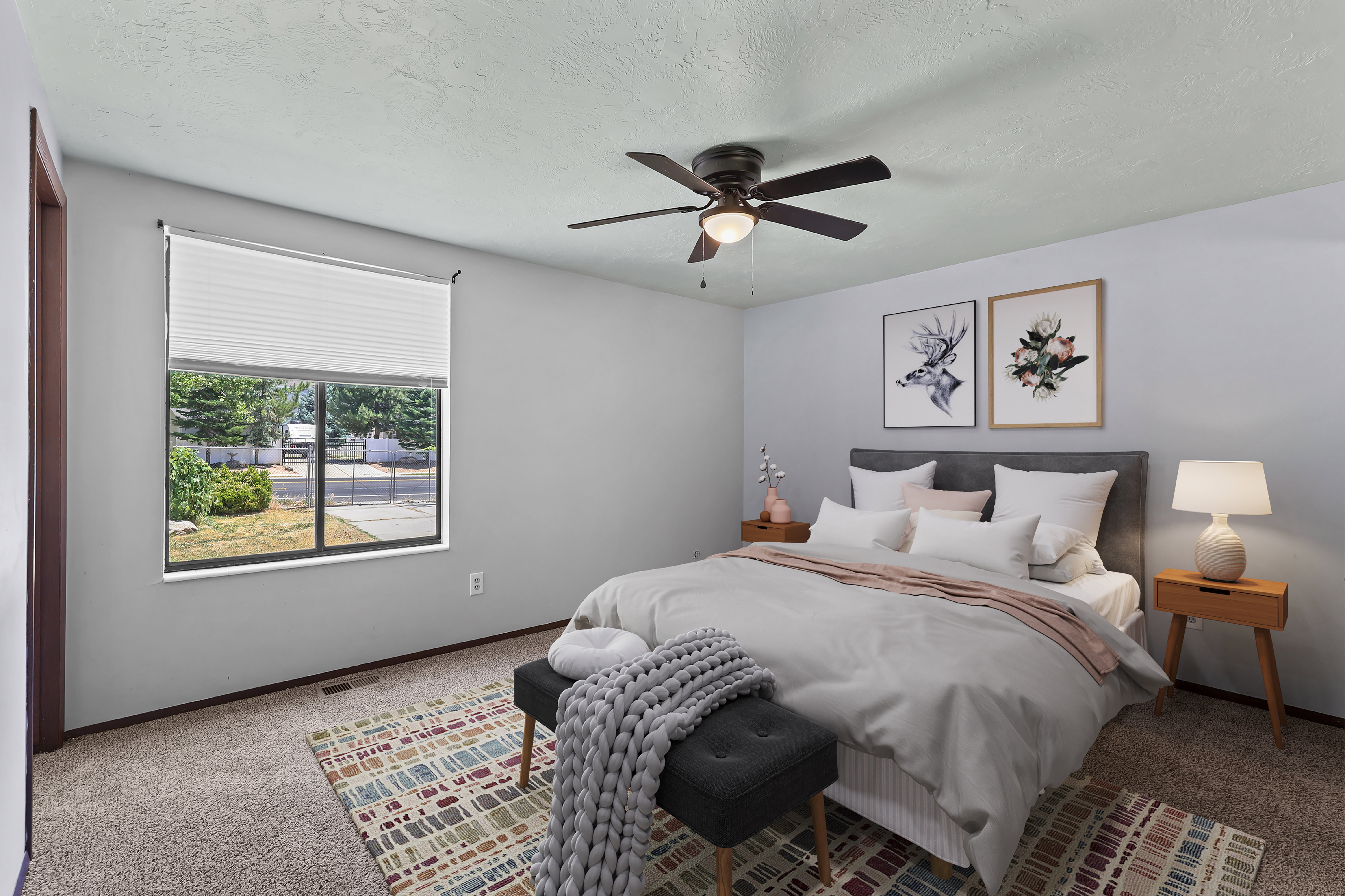 Carpeted bedroom featuring a large window with white blinds, a ceiling fan with integrated lighting, and light gray wall paint