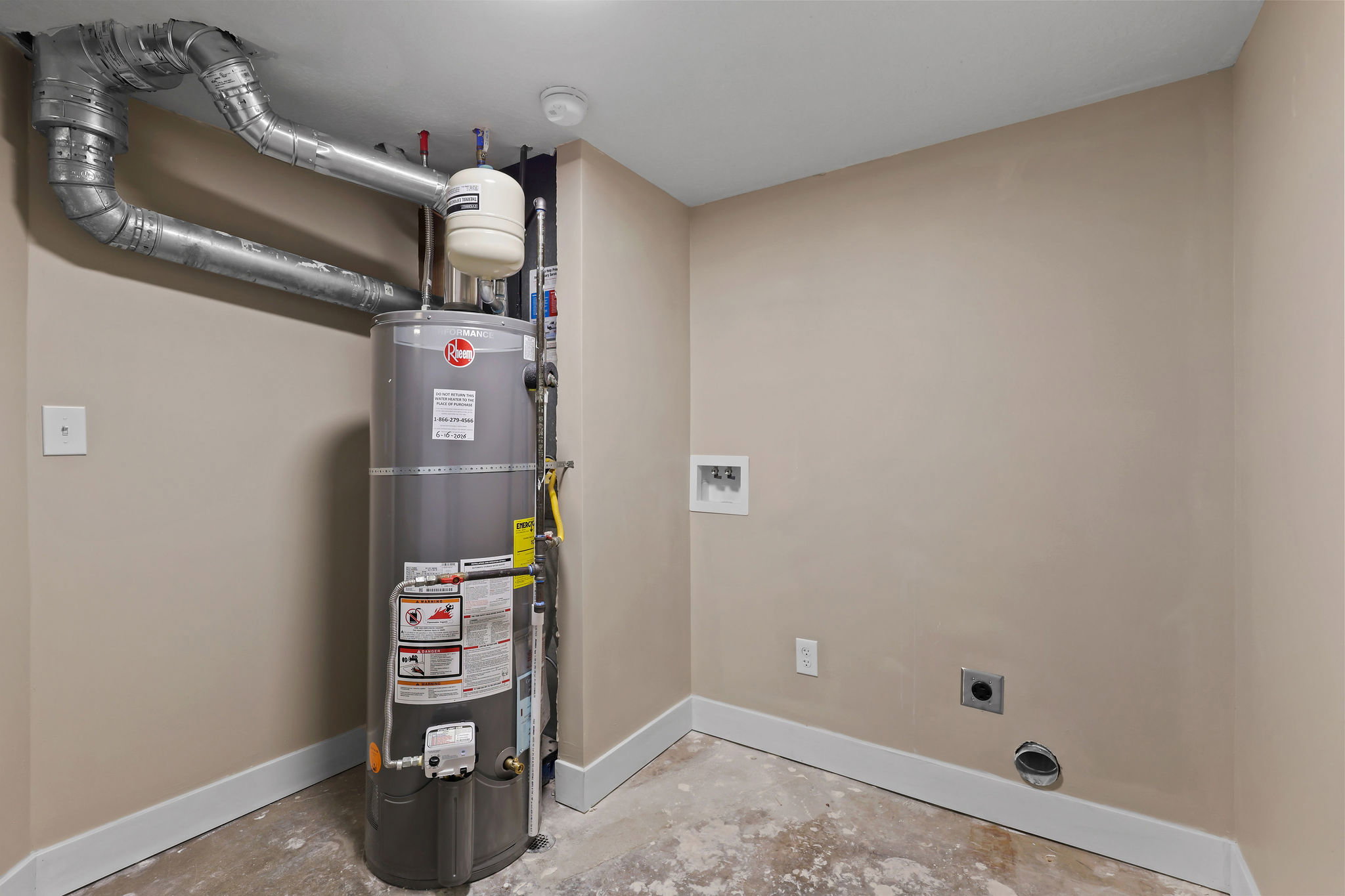 Utility area featuring a water heater, visible ductwork, and laundry hookups