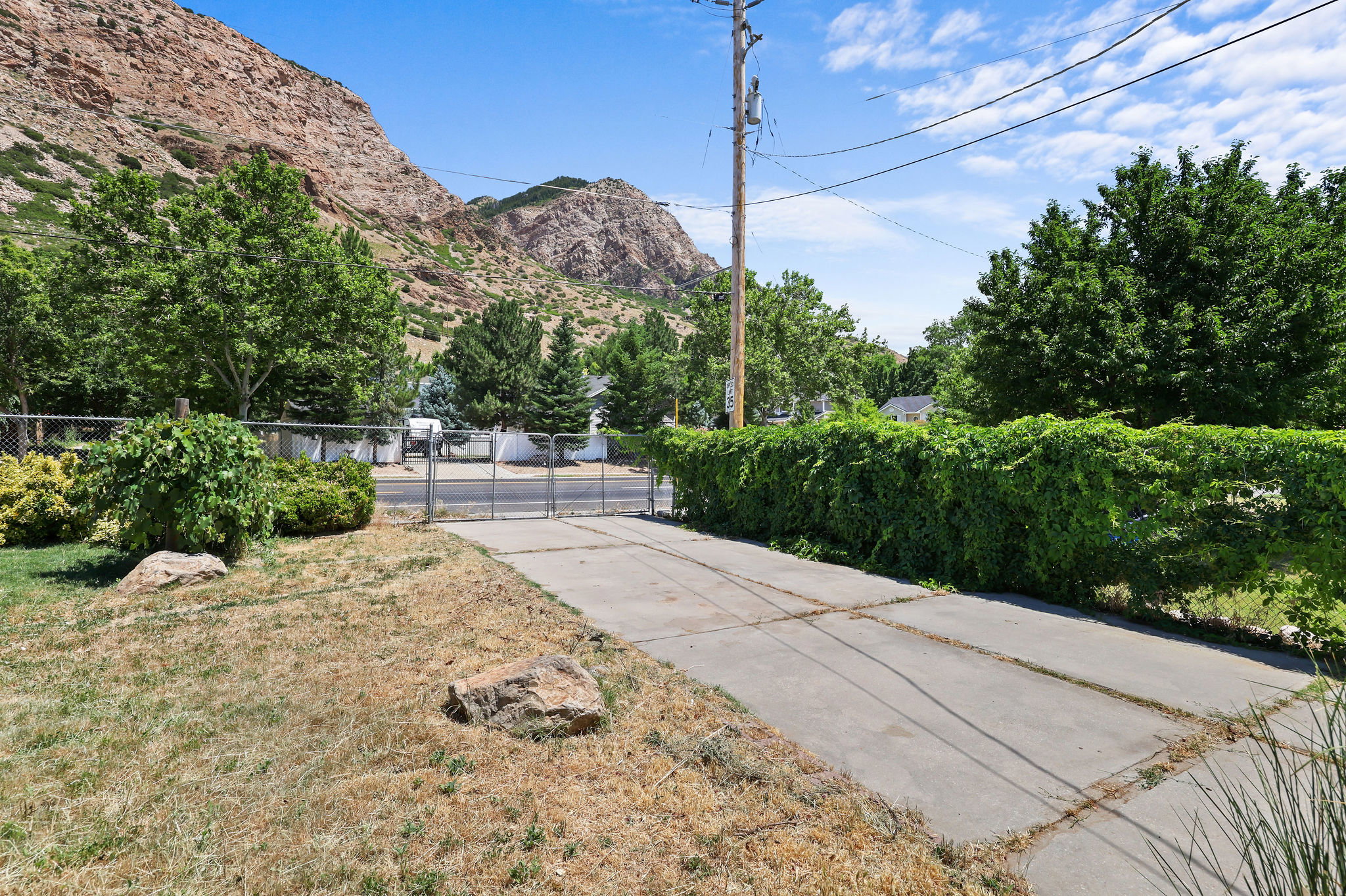 Second driveway offering plenty of parking for vehicles, RVs, trailers, or guests.