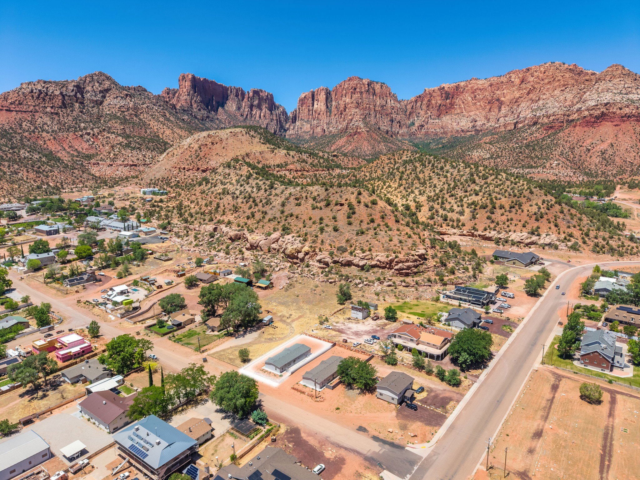 Aerial perspective showcasing a residential community nestled against a backdrop of red rock mountains