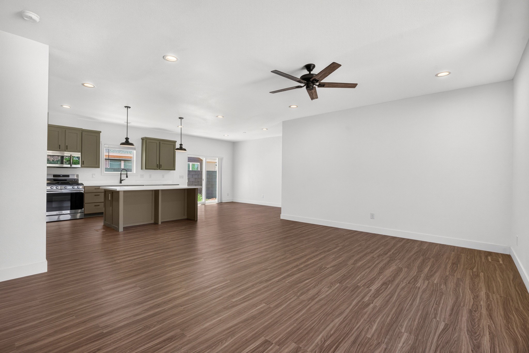 Open-concept living space featuring wood-finish flooring and recessed lighting