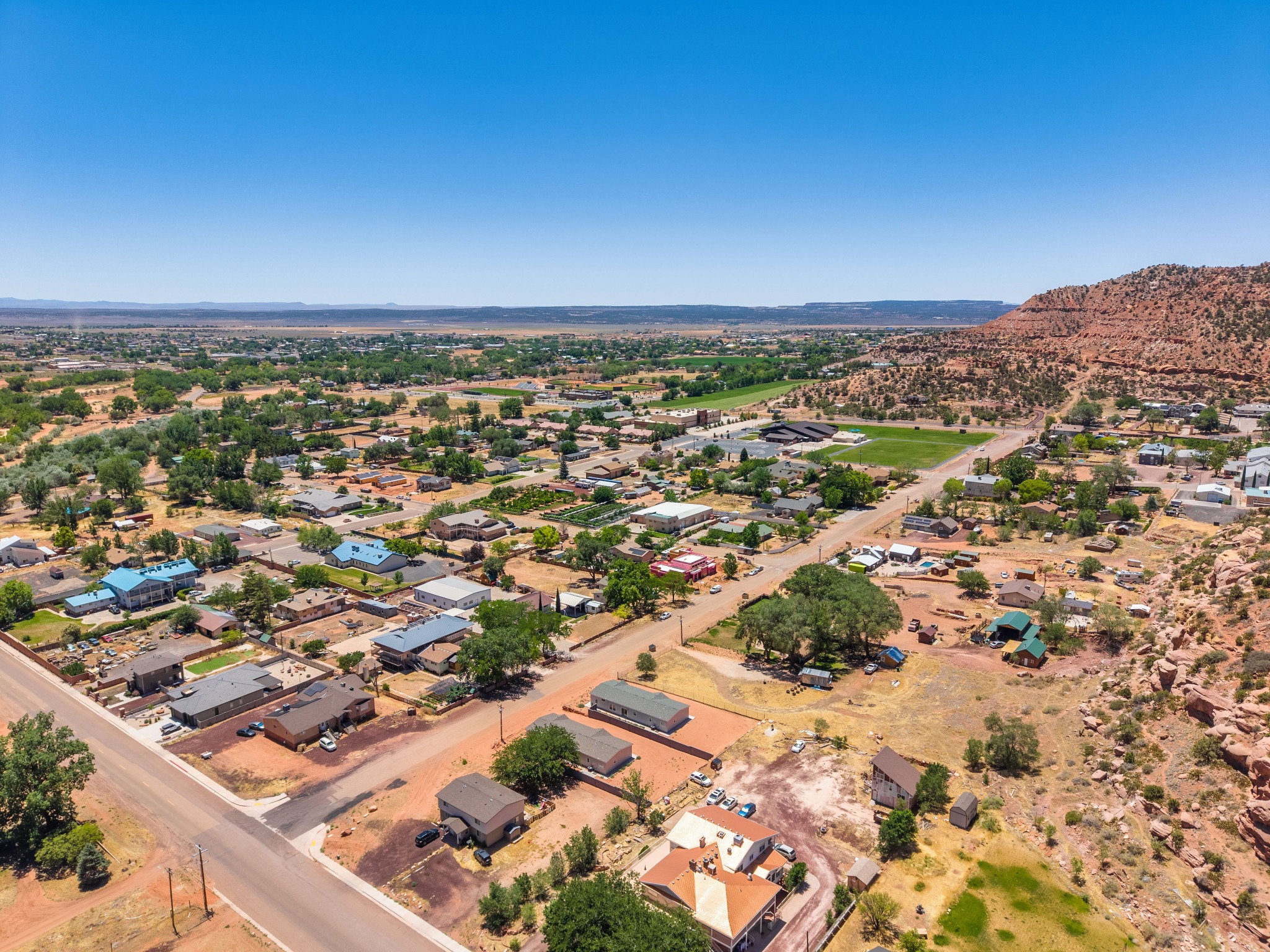 Expansive aerial perspective showcasing a residential community with abundant mature trees and natural desert landscaping
