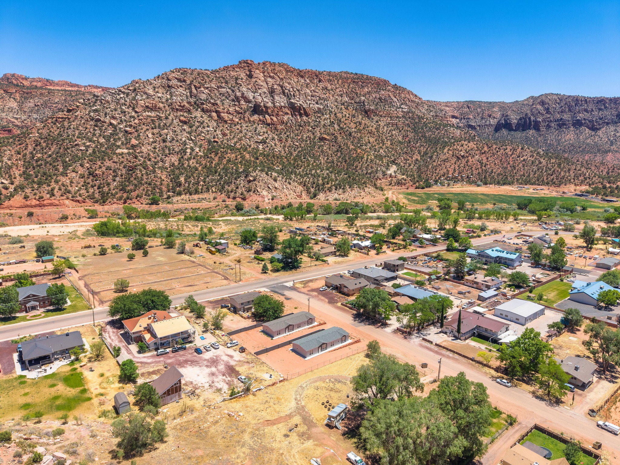 Expansive property featuring multiple structures, including residential buildings and a larger commercial-style building with a metal roof