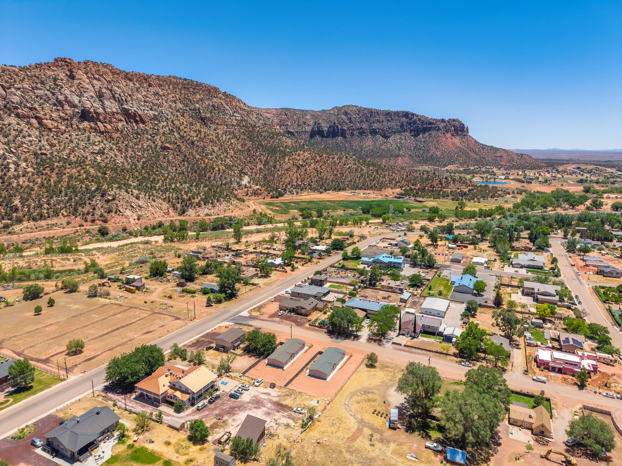 Expansive aerial perspective showcasing a townscape nestled against a large, rugged mountain range
