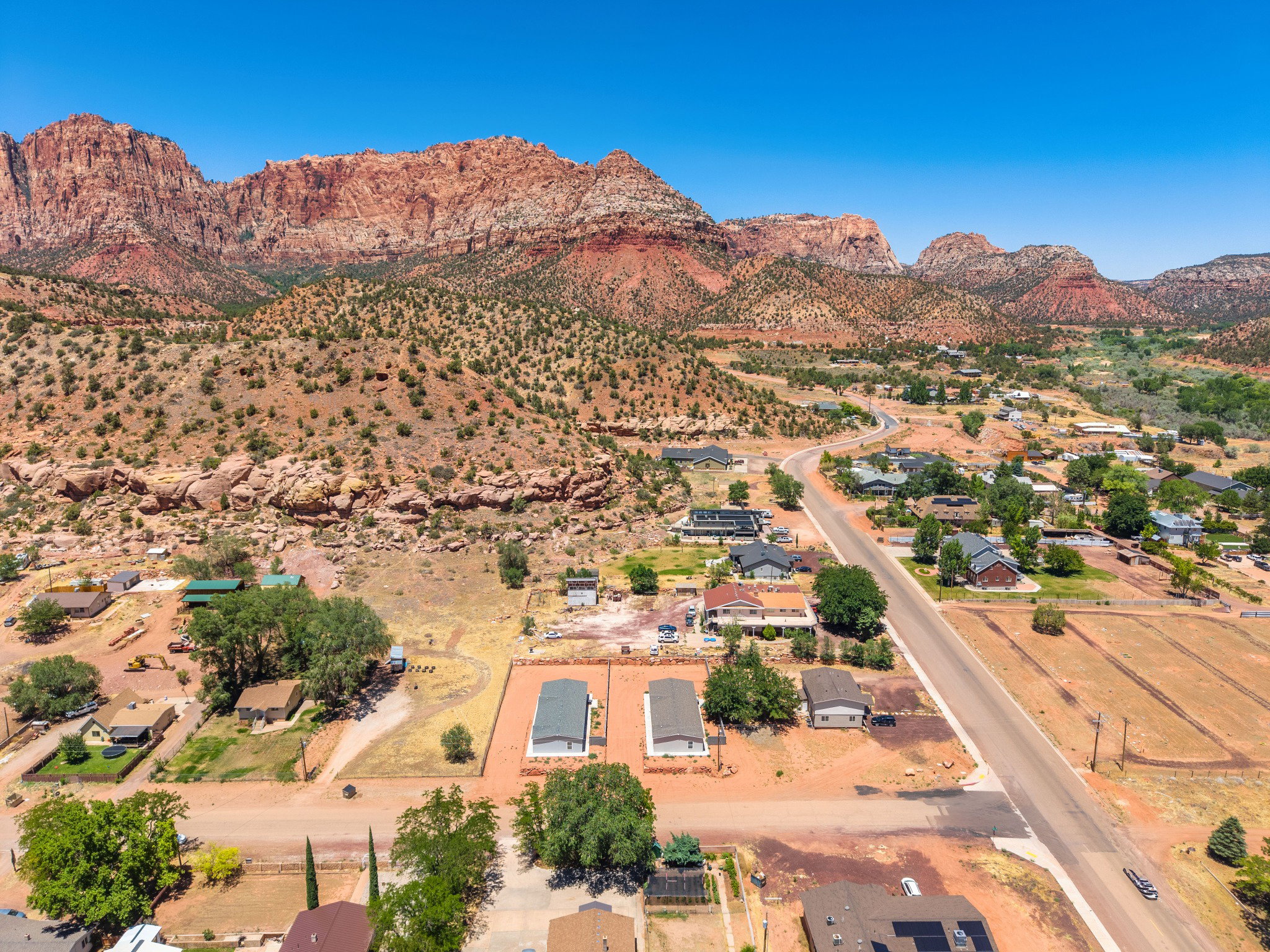 Expansive aerial perspective showcasing a scenic backdrop of red rock mountains
