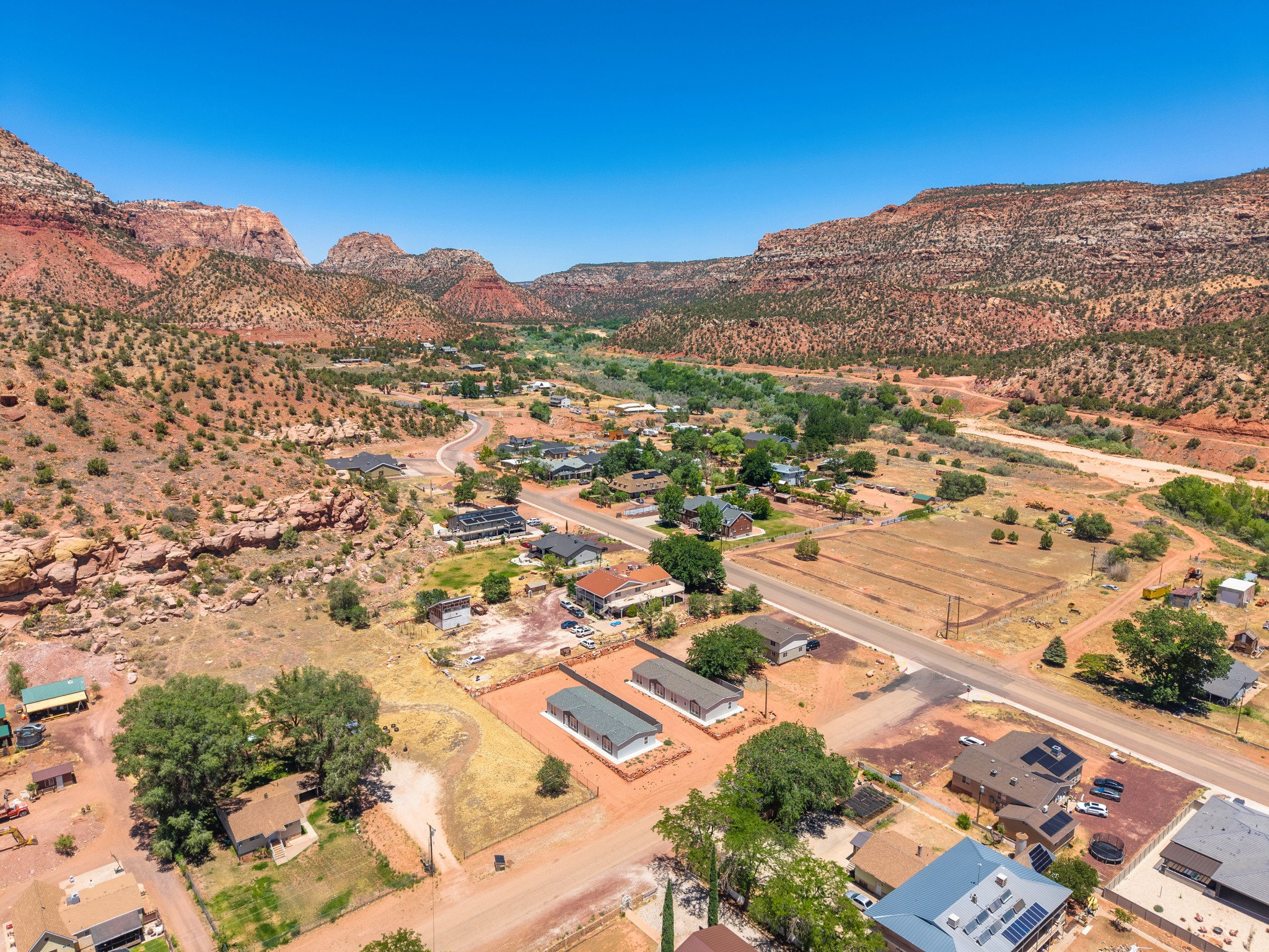 Townsite nestled within a desert landscape featuring prominent red rock formations