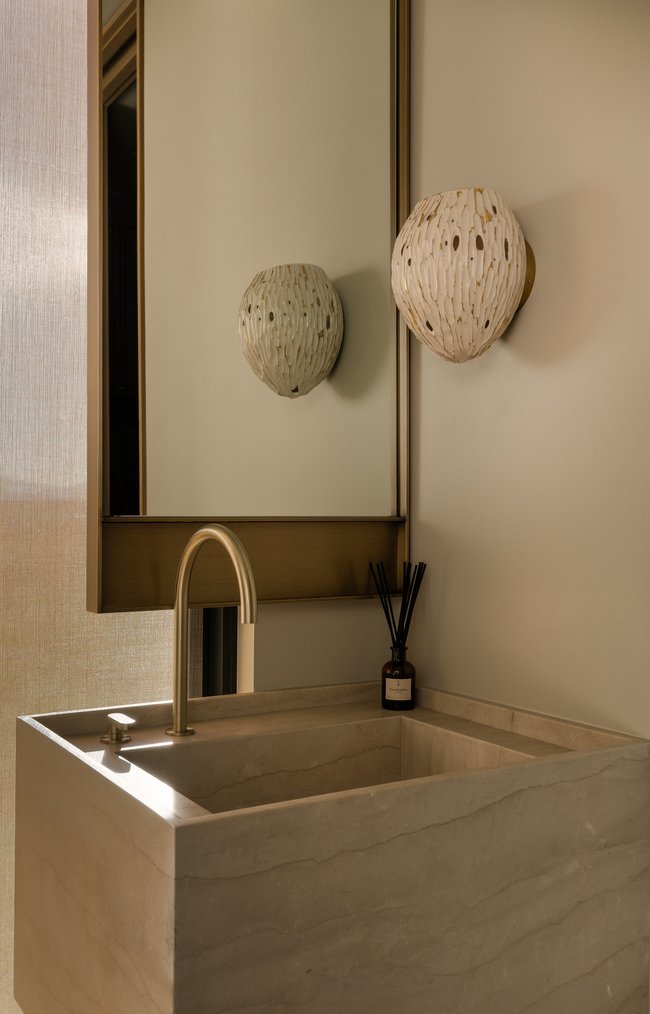 Integrated stone vanity with an undermount sink and a brushed brass faucet