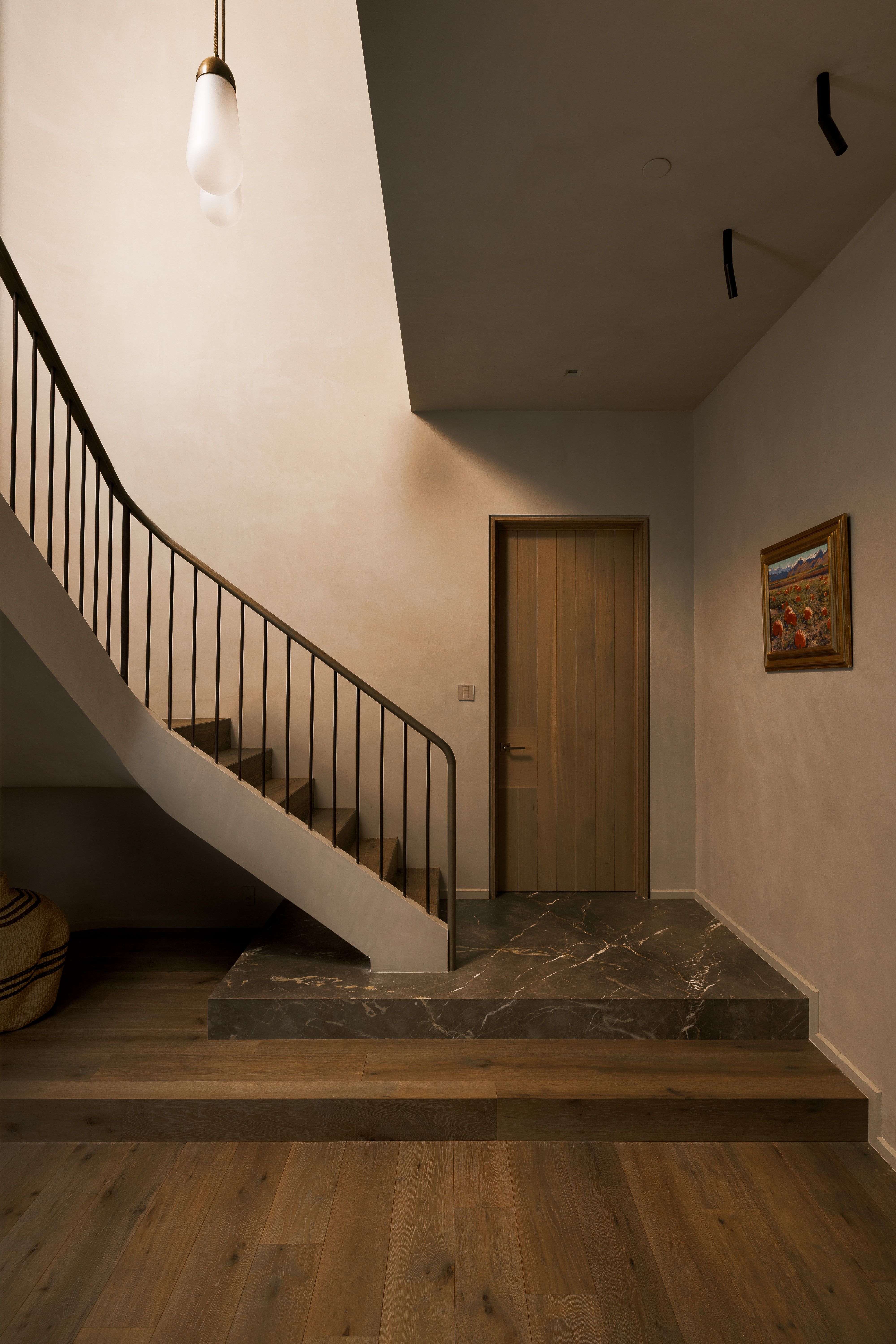 Curved staircase featuring metal balusters and a dark handrail