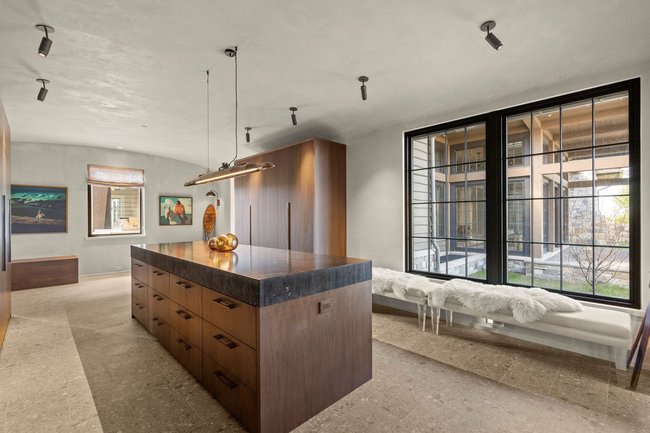 Spacious room featuring a large central island with a stone countertop and integrated storage