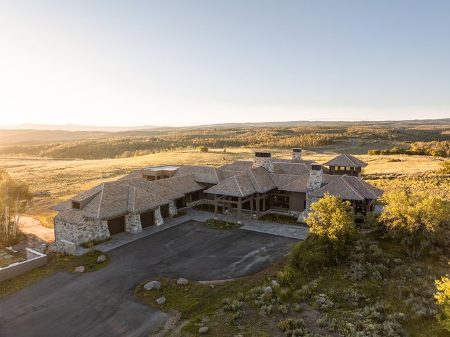 Expansive property featuring a stone and wood exterior with multiple gables