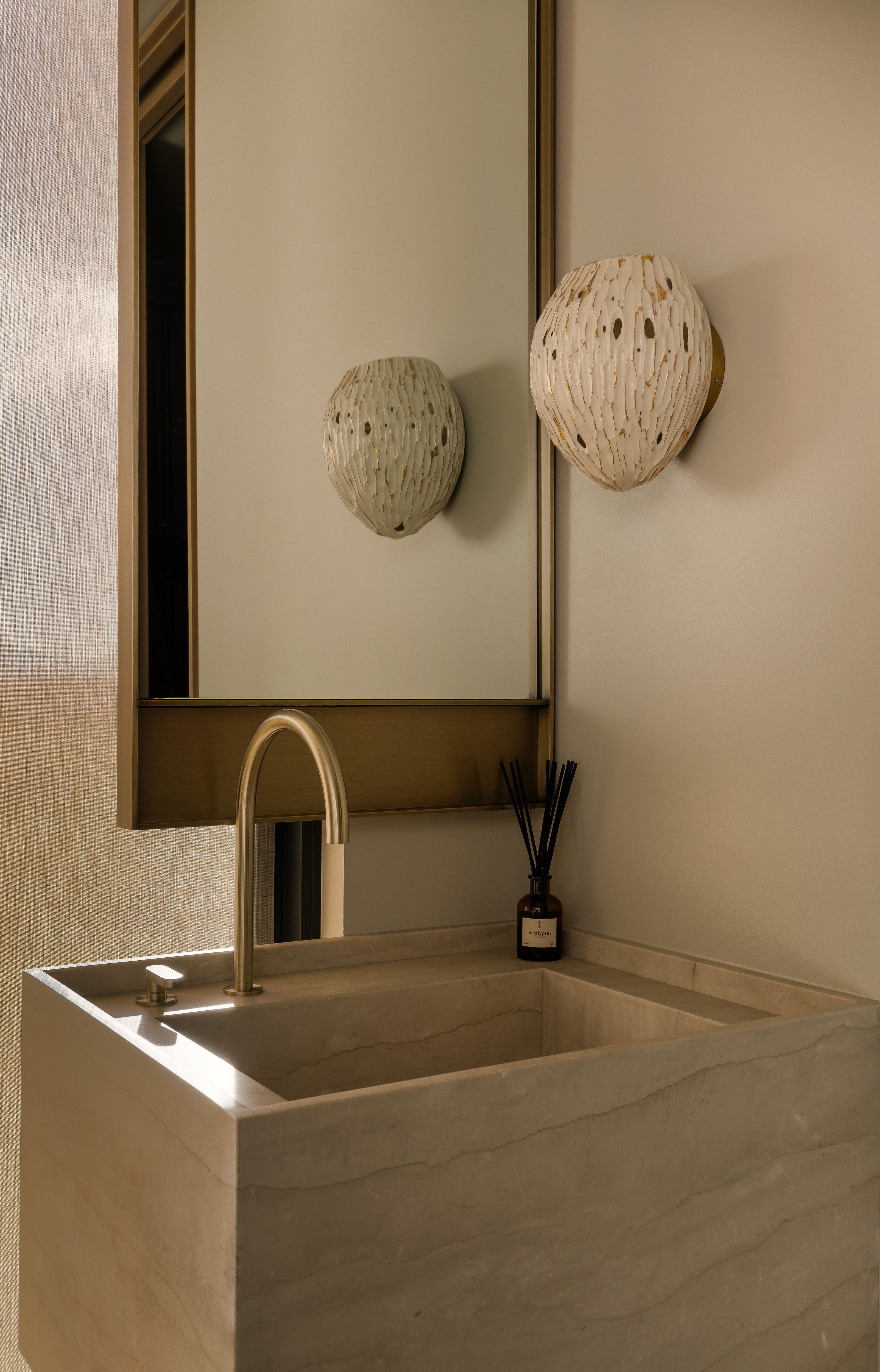 Integrated stone sink and countertop with a wall-mounted brass faucet