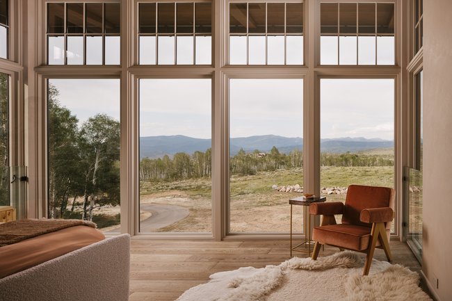 Expansive window wall with transom windows and natural wood-finish flooring