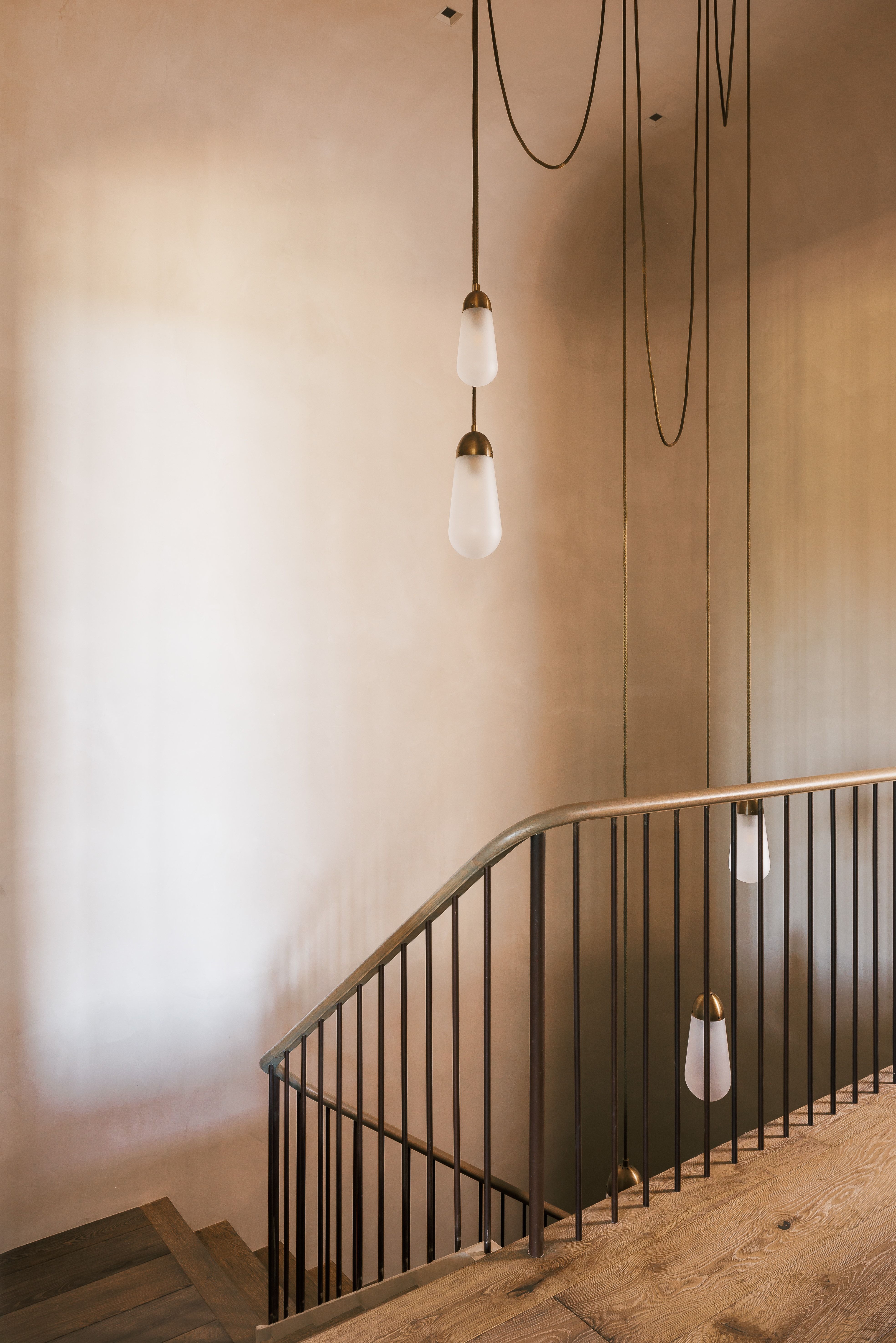 Hardwood staircase featuring a metal railing with vertical balusters