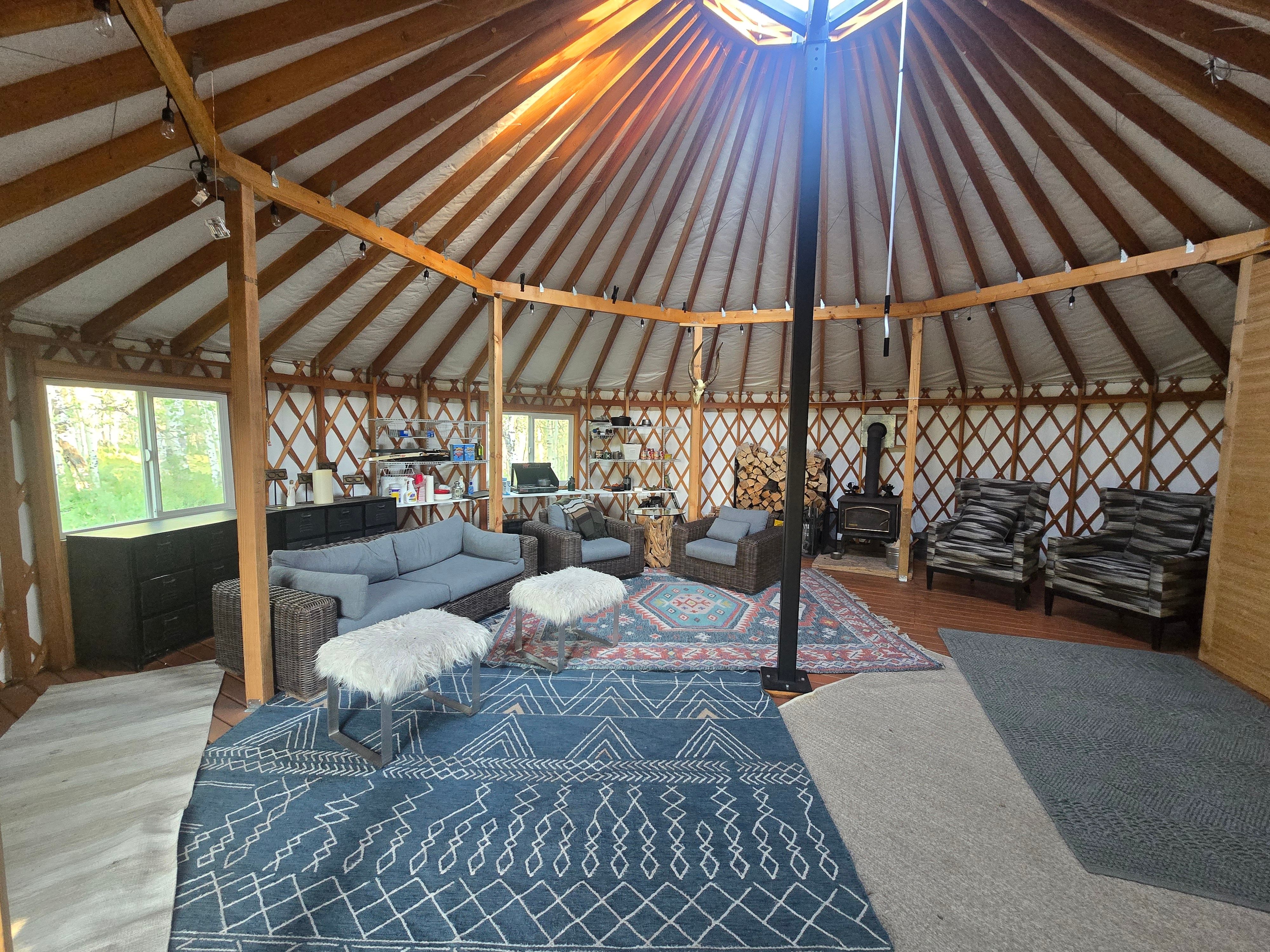 Open-concept circular structure featuring exposed wooden ceiling beams and latticework