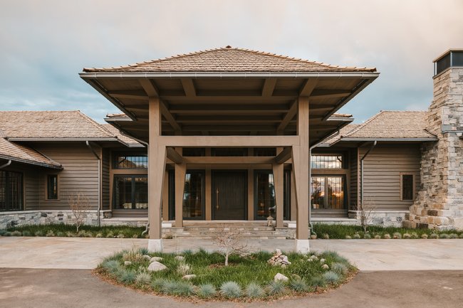 Striking architectural facade featuring a prominent covered entryway with exposed beams