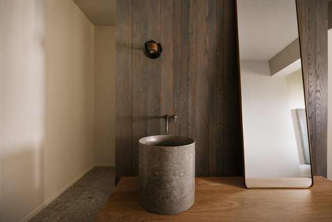 Stone vessel sink on a wood-finish countertop