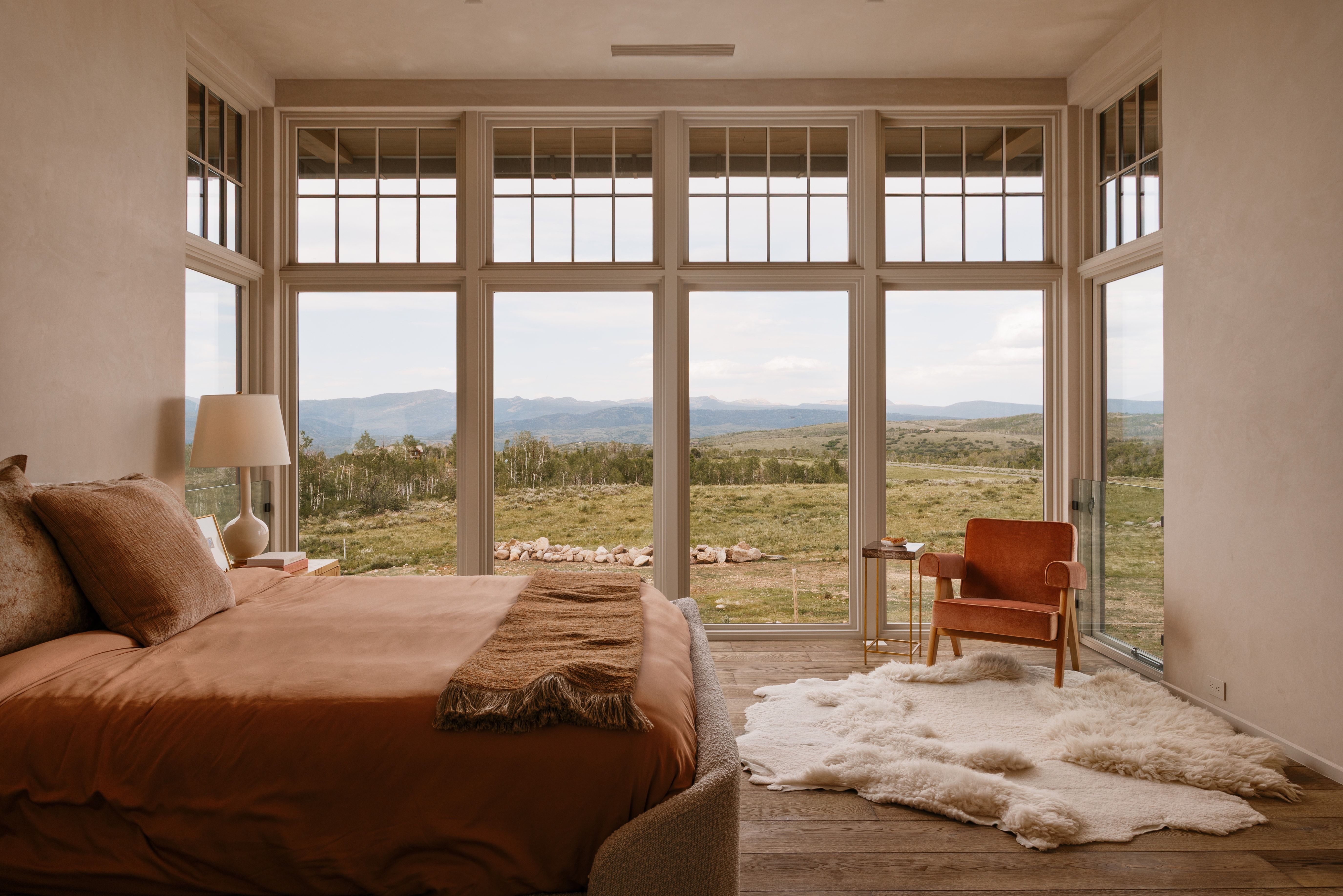 Expansive floor-to-ceiling windows featuring transoms overlooking a mountainous landscape