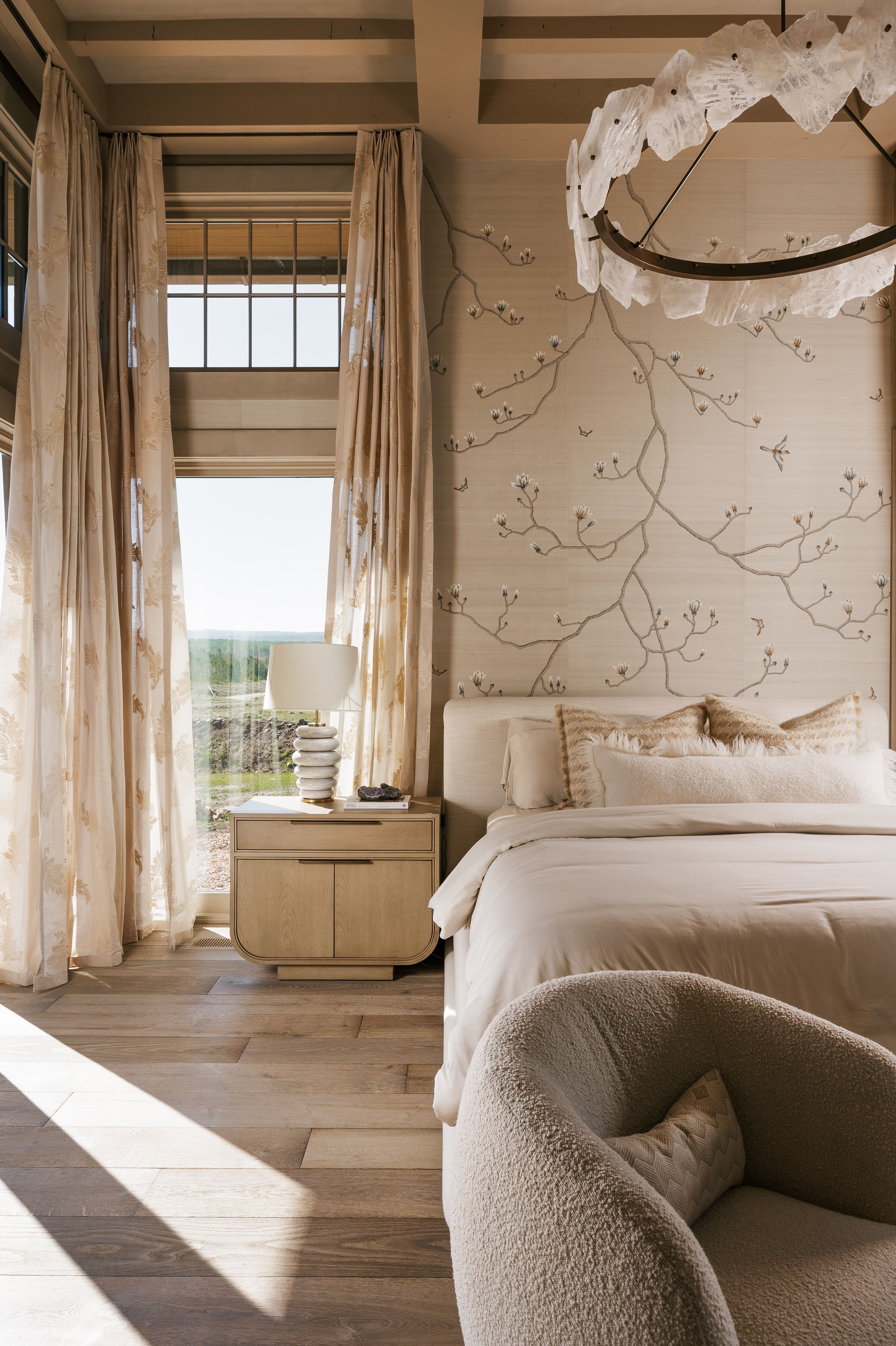 Bedroom featuring wood-finish flooring, a decorative accent wall, and a large window with transom