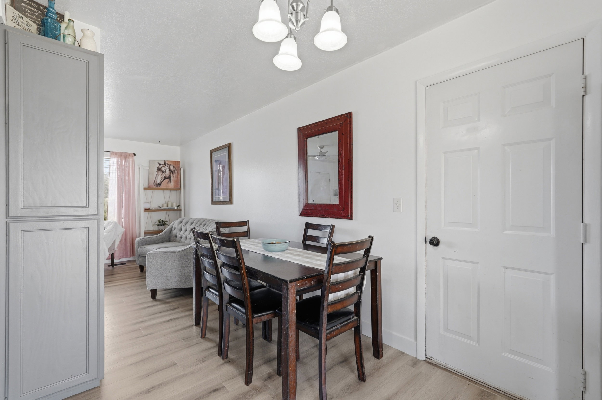 Dining area featuring wood-finish flooring, white walls, and a multi-light ceiling fixture