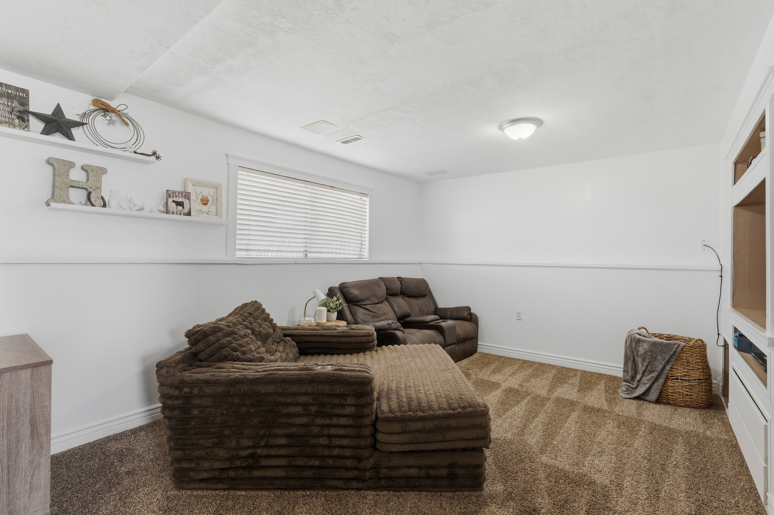 Carpeted room featuring white walls with wainscoting, a flush-mount ceiling light, and a window with blinds