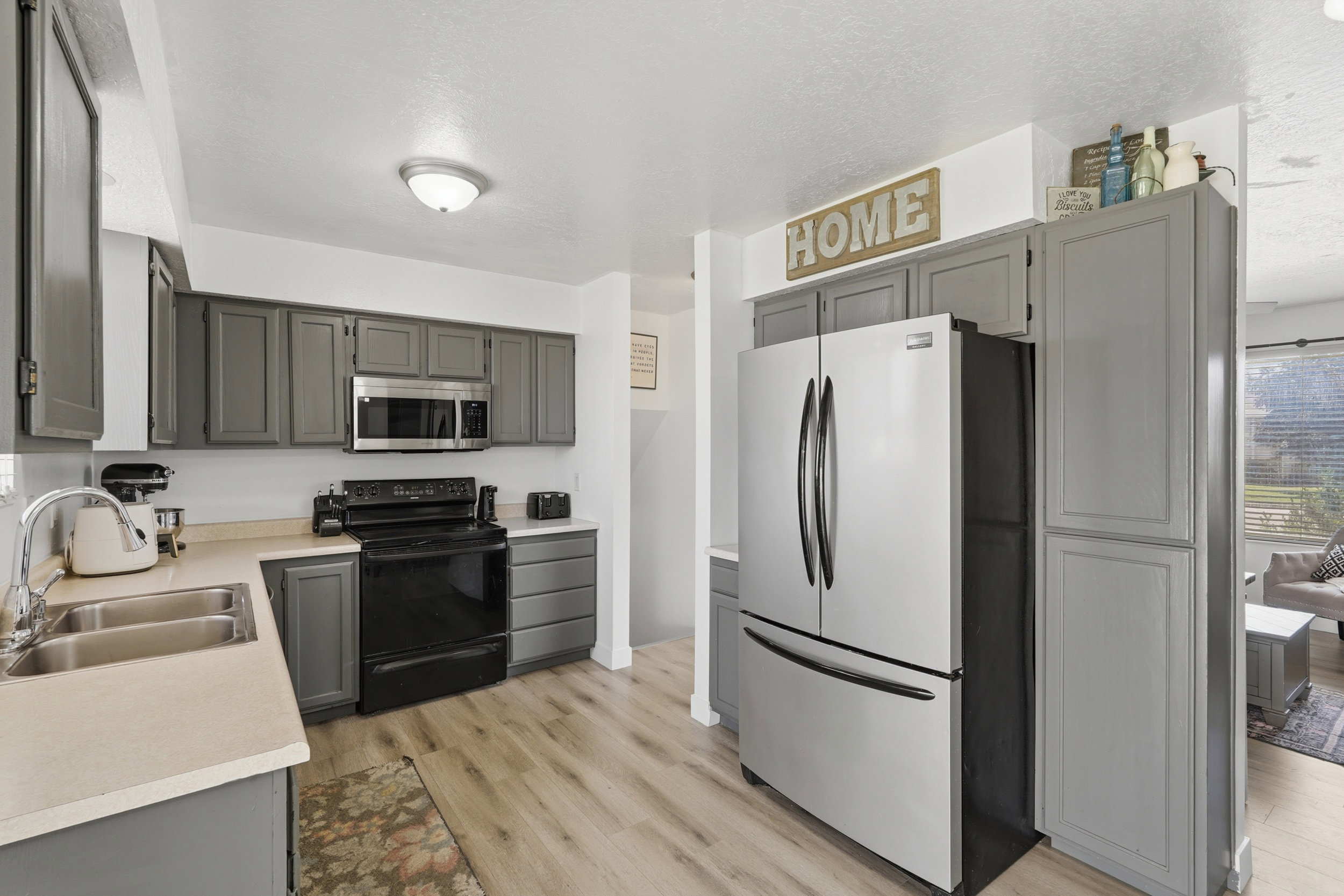 Kitchen featuring wood-finish flooring and grey cabinetry