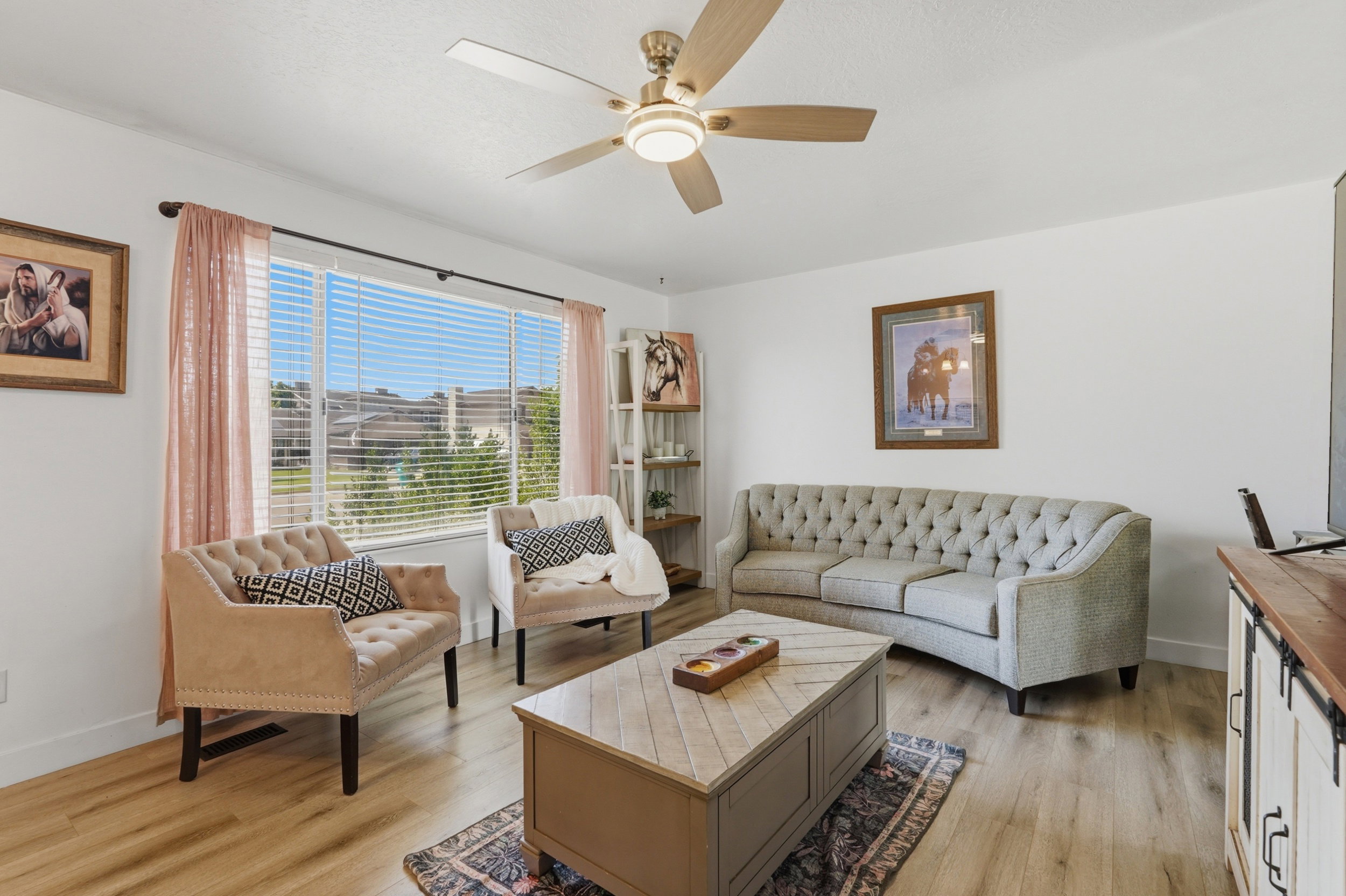 Spacious living area featuring light wood-finish flooring and ample natural light from a large window