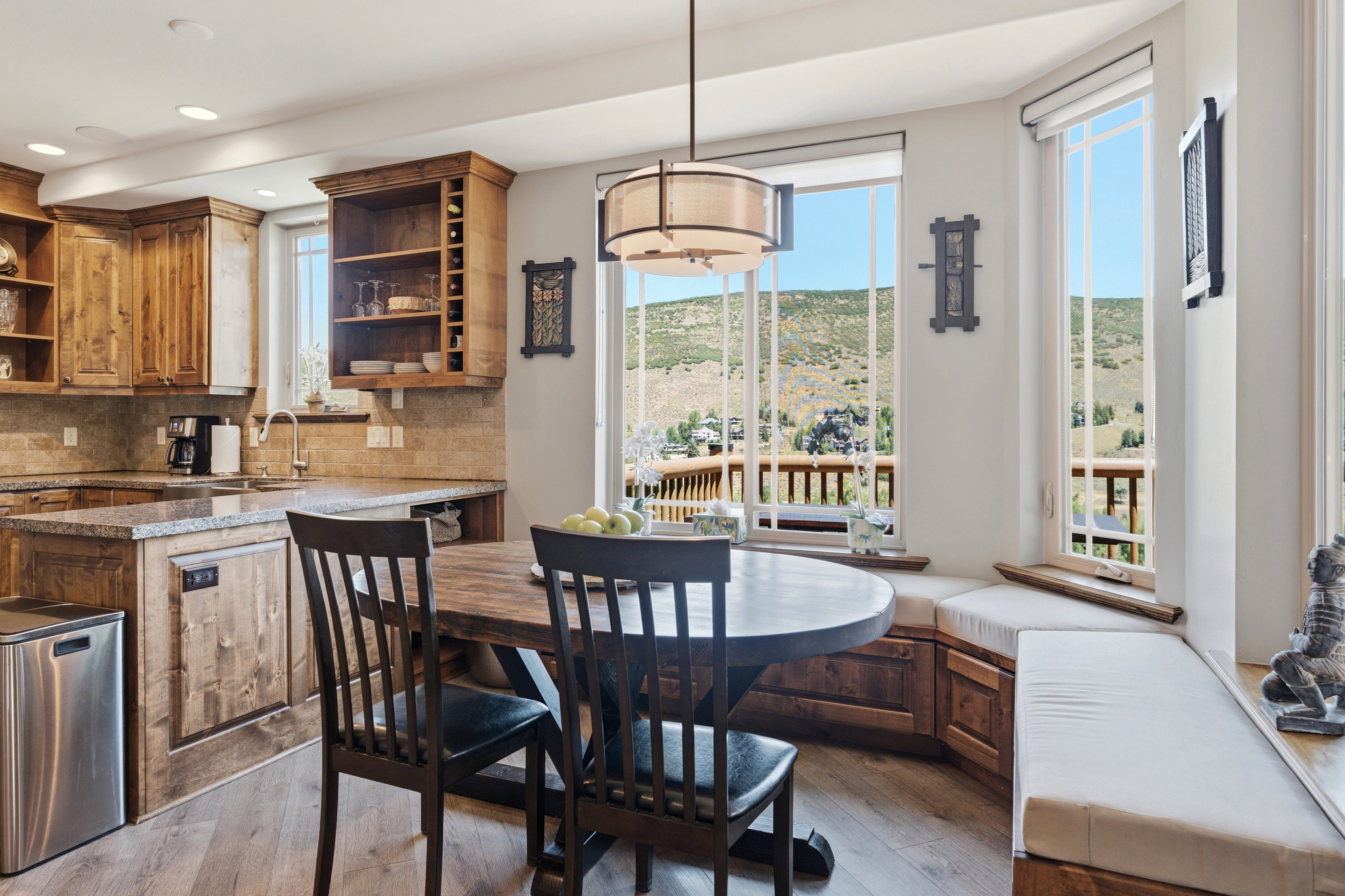 Kitchen and dining area featuring a built-in bench with storage, a circular wood-finish table, and wood-finish cabinetry
