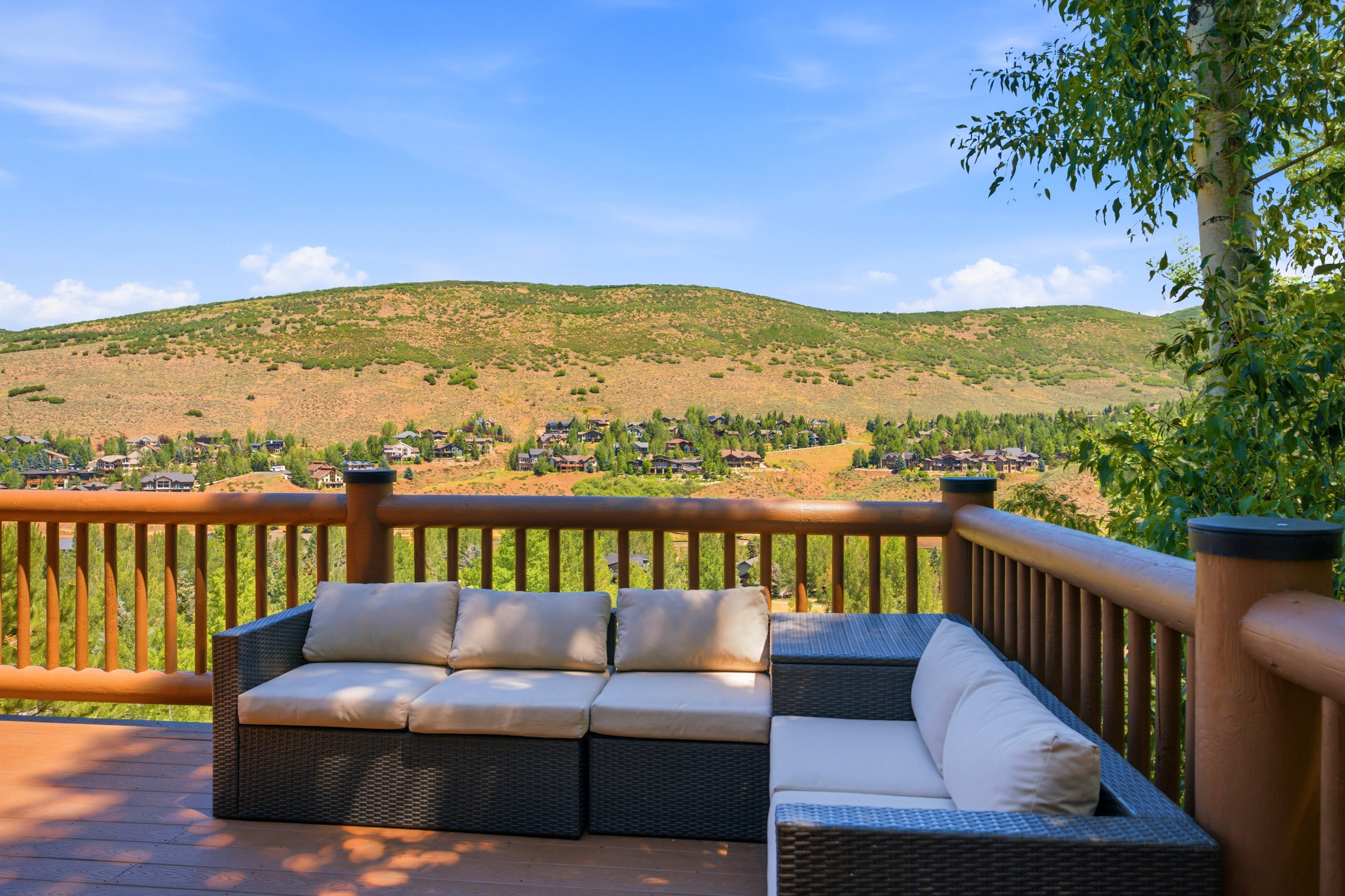 Expansive outdoor deck featuring wood-finish flooring and a robust wood railing