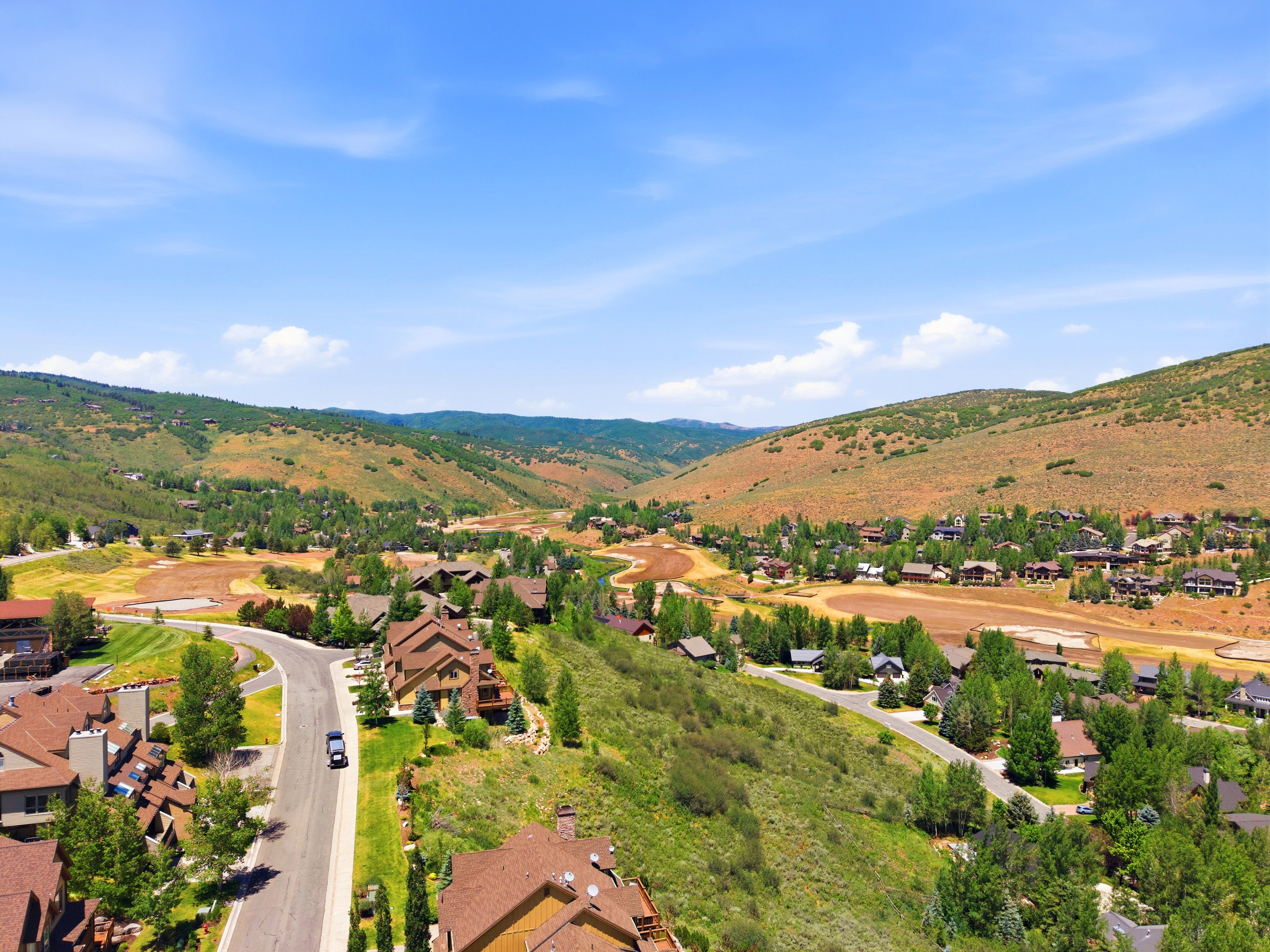 Expansive hillside community with multiple residences, established roadways, and abundant mature trees