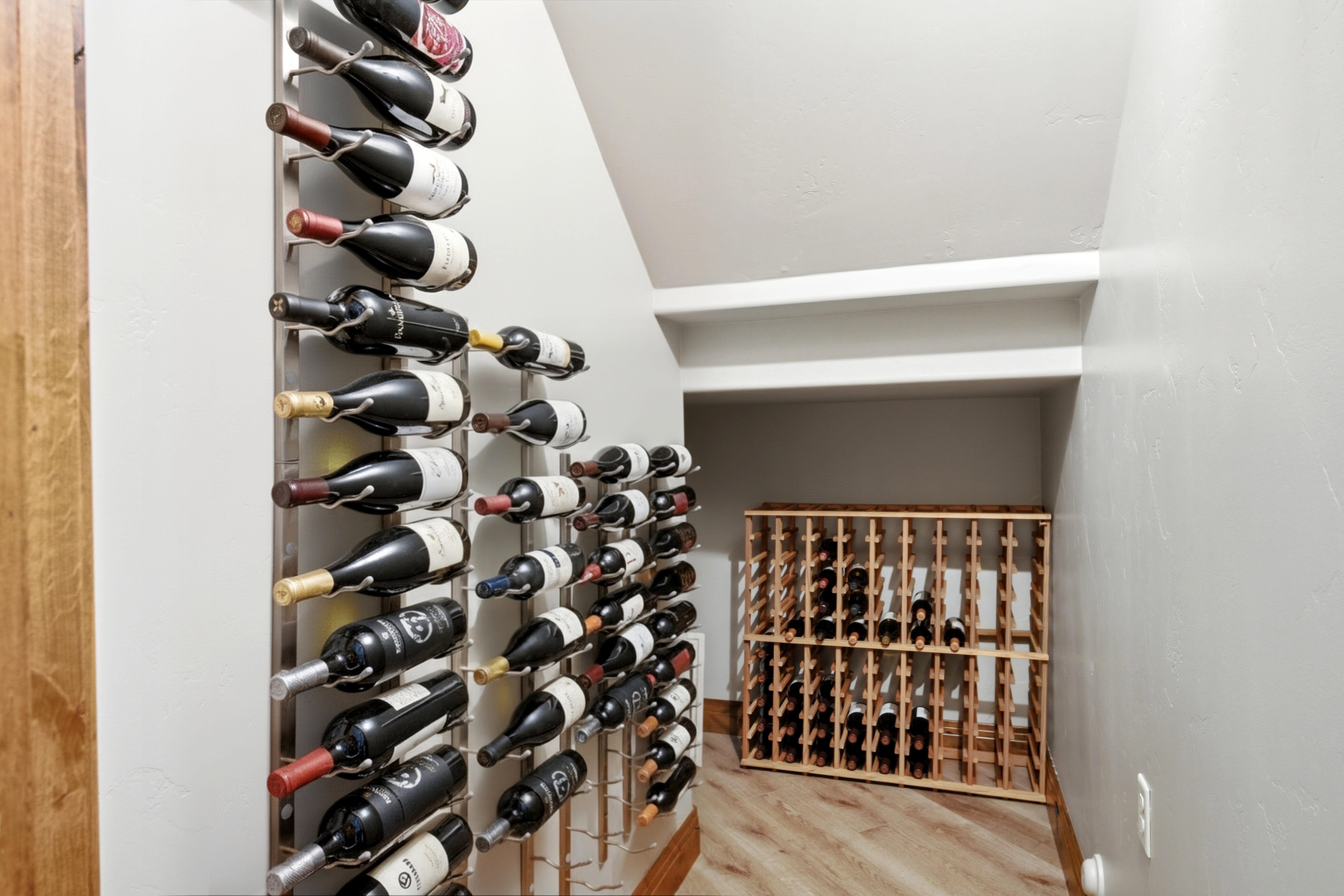 Dedicated wine storage space featuring multiple wall-mounted metal racks and a freestanding wooden wine rack
