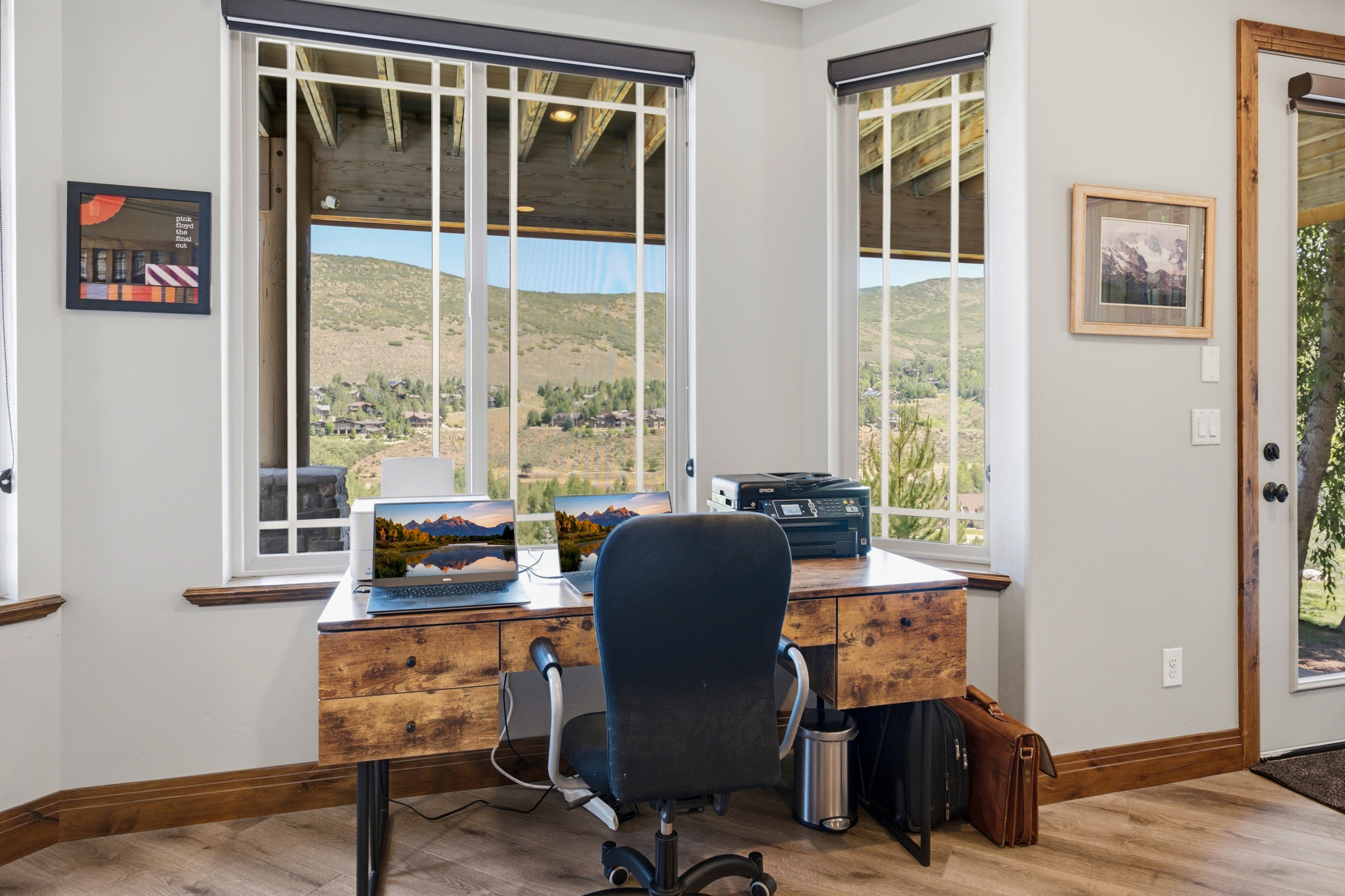 Space featuring expansive windows, a wood-finish desk, and durable baseboards