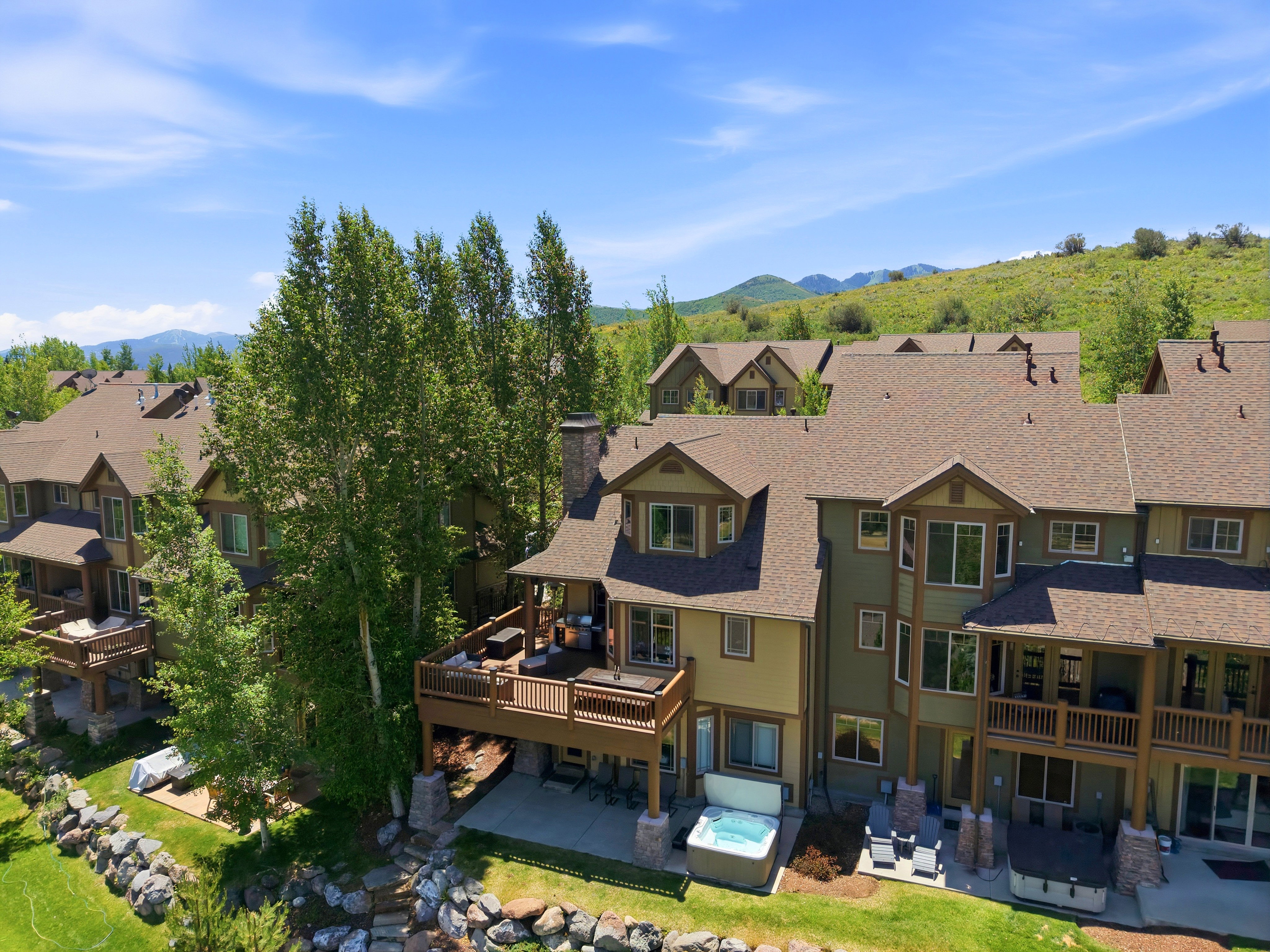 Multi-level dwelling with an expansive outdoor deck and a lower-level patio