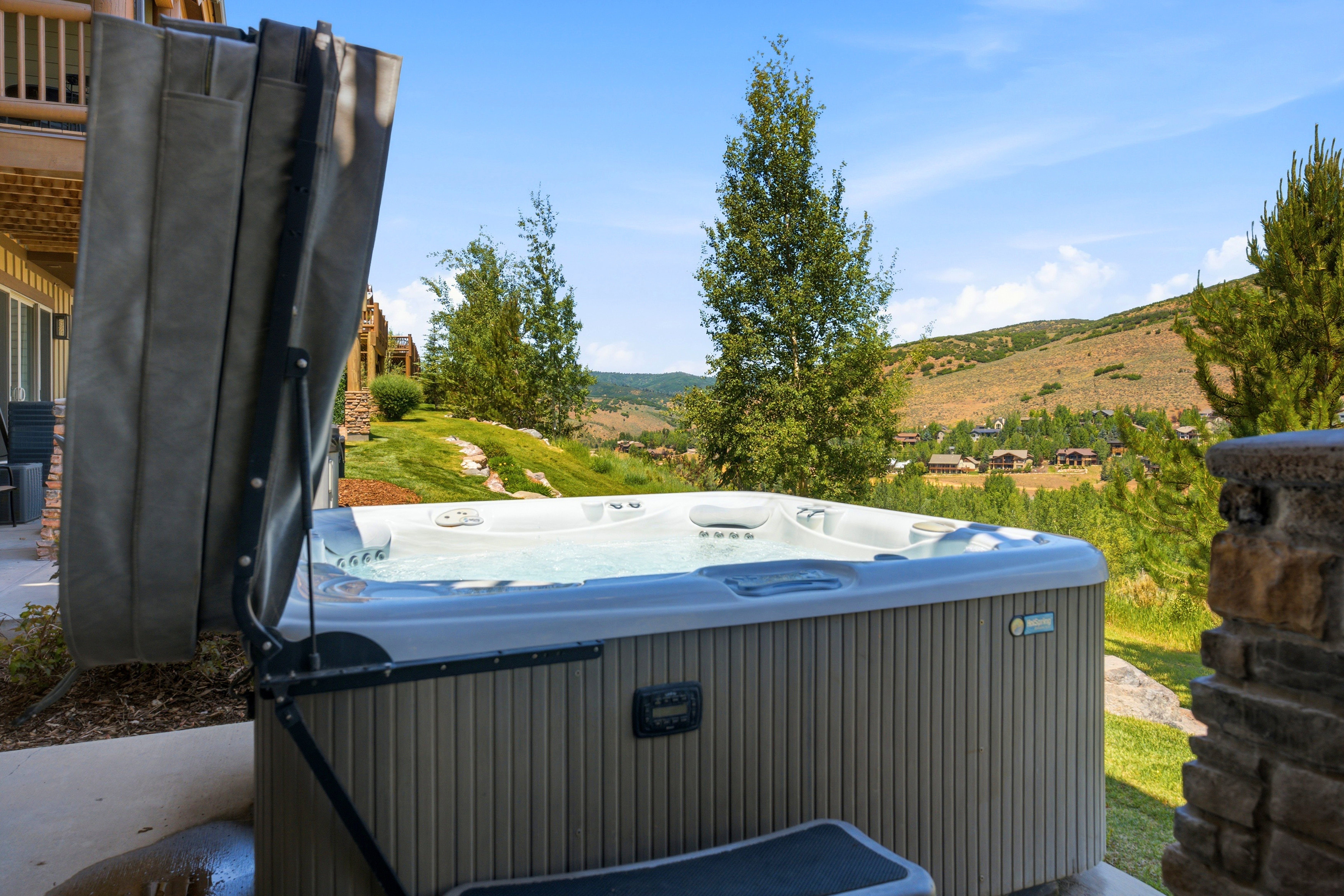 Outdoor spa featuring a light-colored shell, ribbed paneling, and a cover lift system