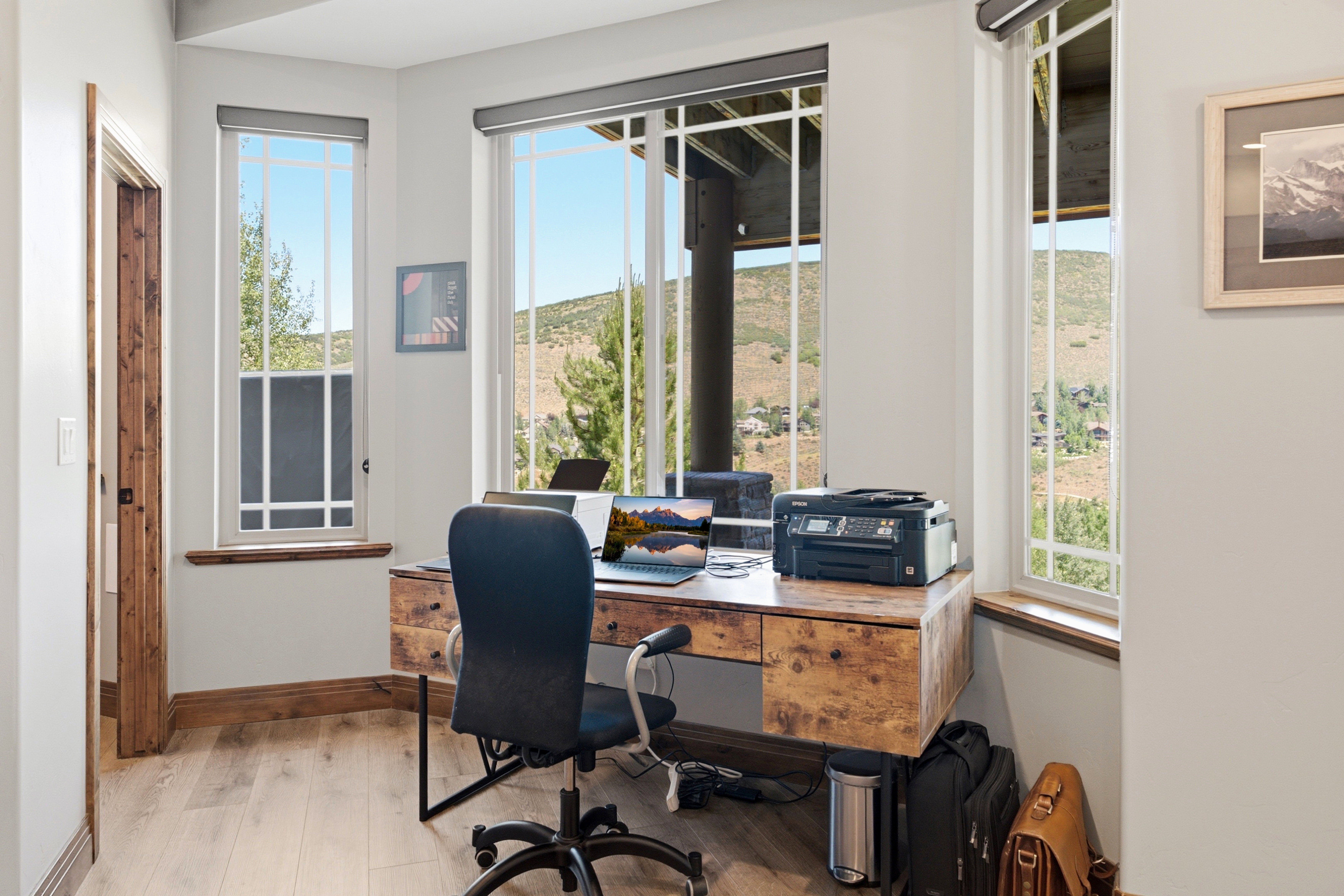 Dedicated office space featuring light wood-finish flooring and a built-in desk with multiple drawers