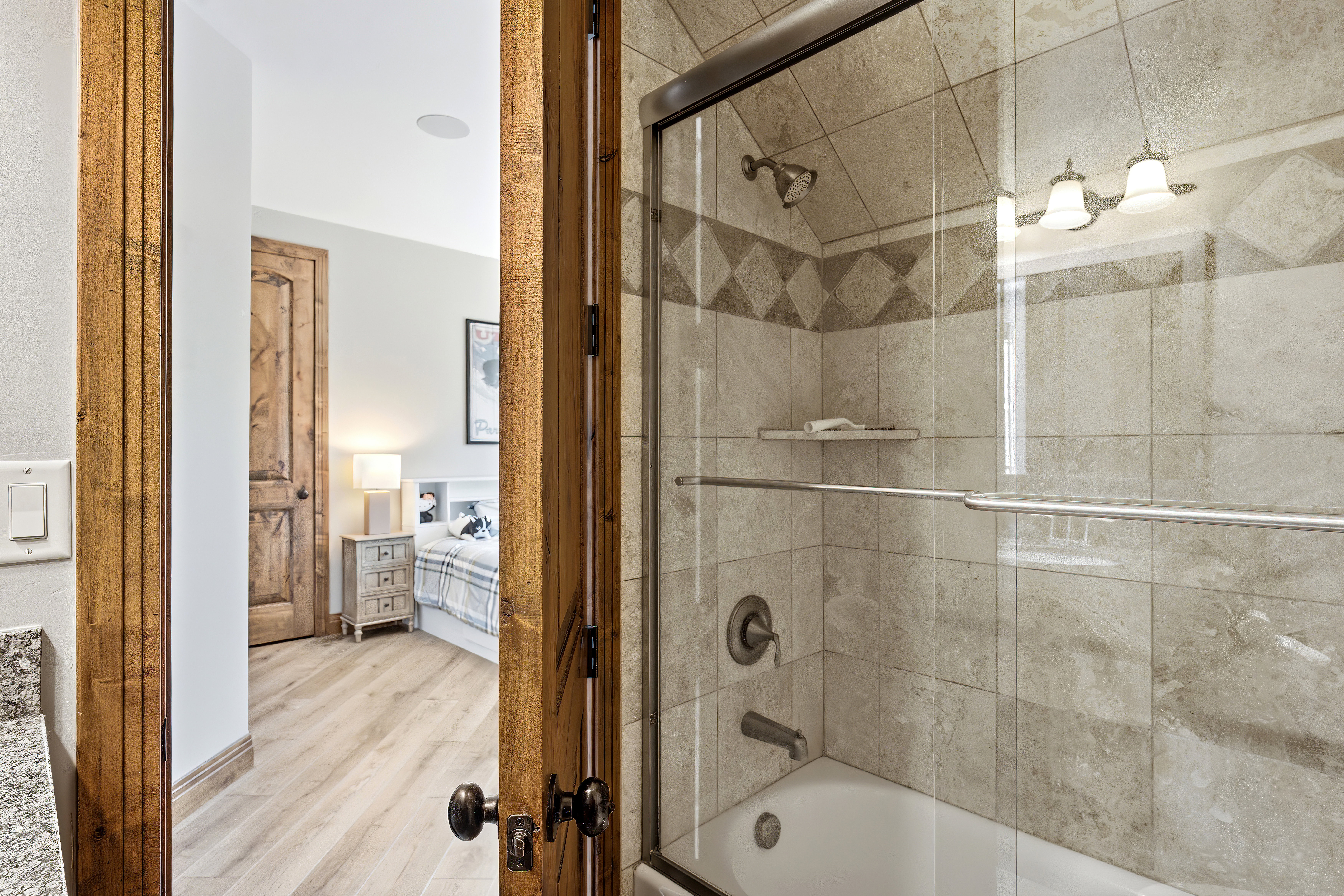 Shower-bathtub combination with glass enclosure and tiled surround
