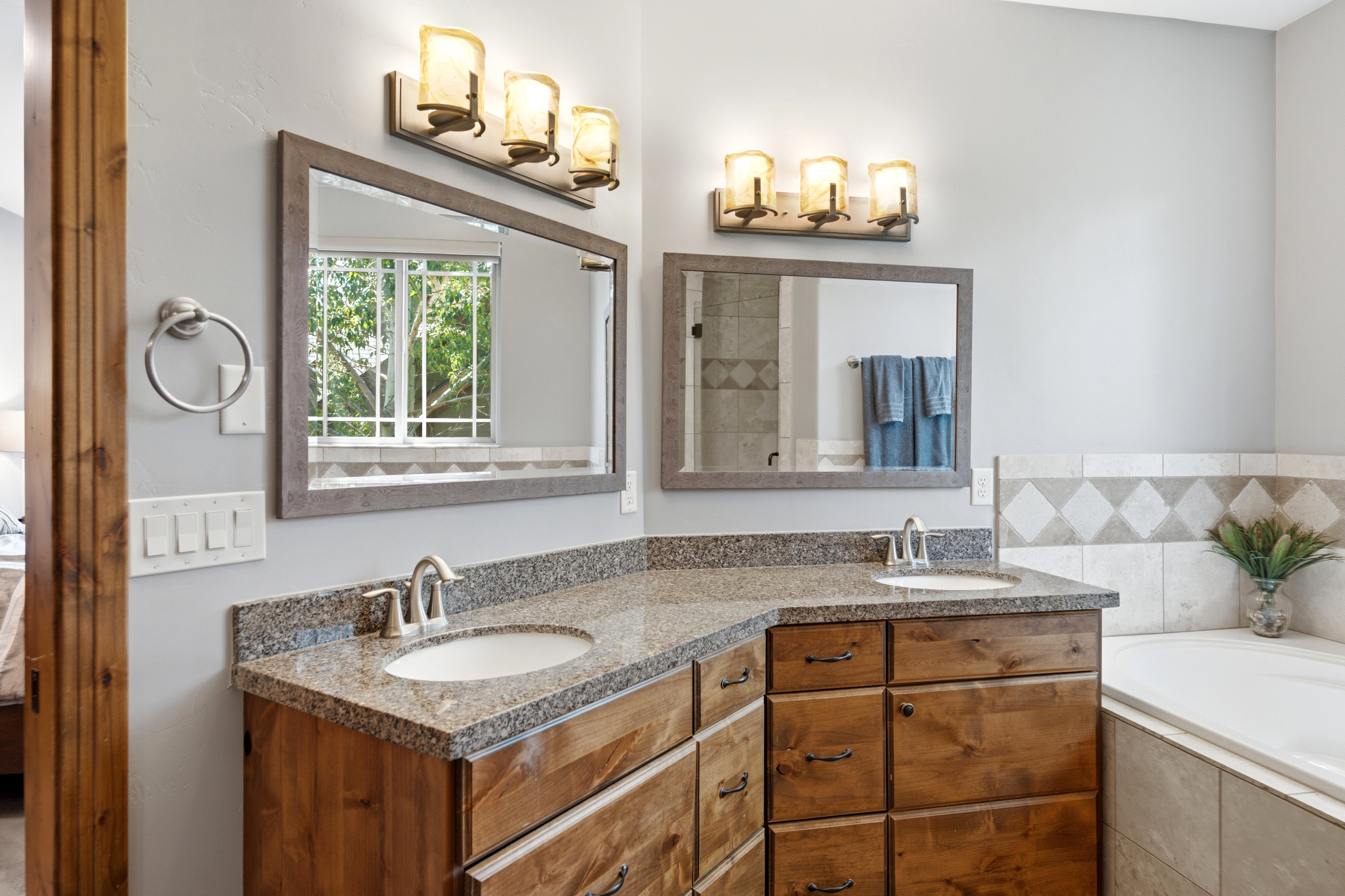 Dual vanity with granite countertops, undermount sinks, and wood cabinetry